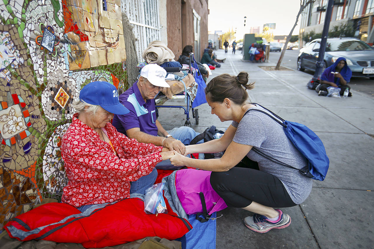 Howard Lipin | The San Diego Union-Tribune                                Karen Adamson, right, prays with Fran Dryden, a homeless woman, in front of God’s Extended Hand Church in the San Diego area. Adamson was a chaperone with students from Chicago who were in town to participate in Urban Missions.