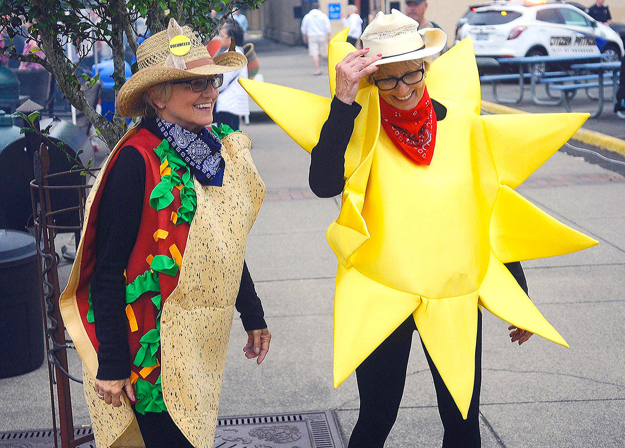 Sumerfest co-founders Bobbi McCracken, left, and Bette Worth take in the event with festive western-themed costumes Saturday. (Hasani Grayson | Grays Harbor News Group)