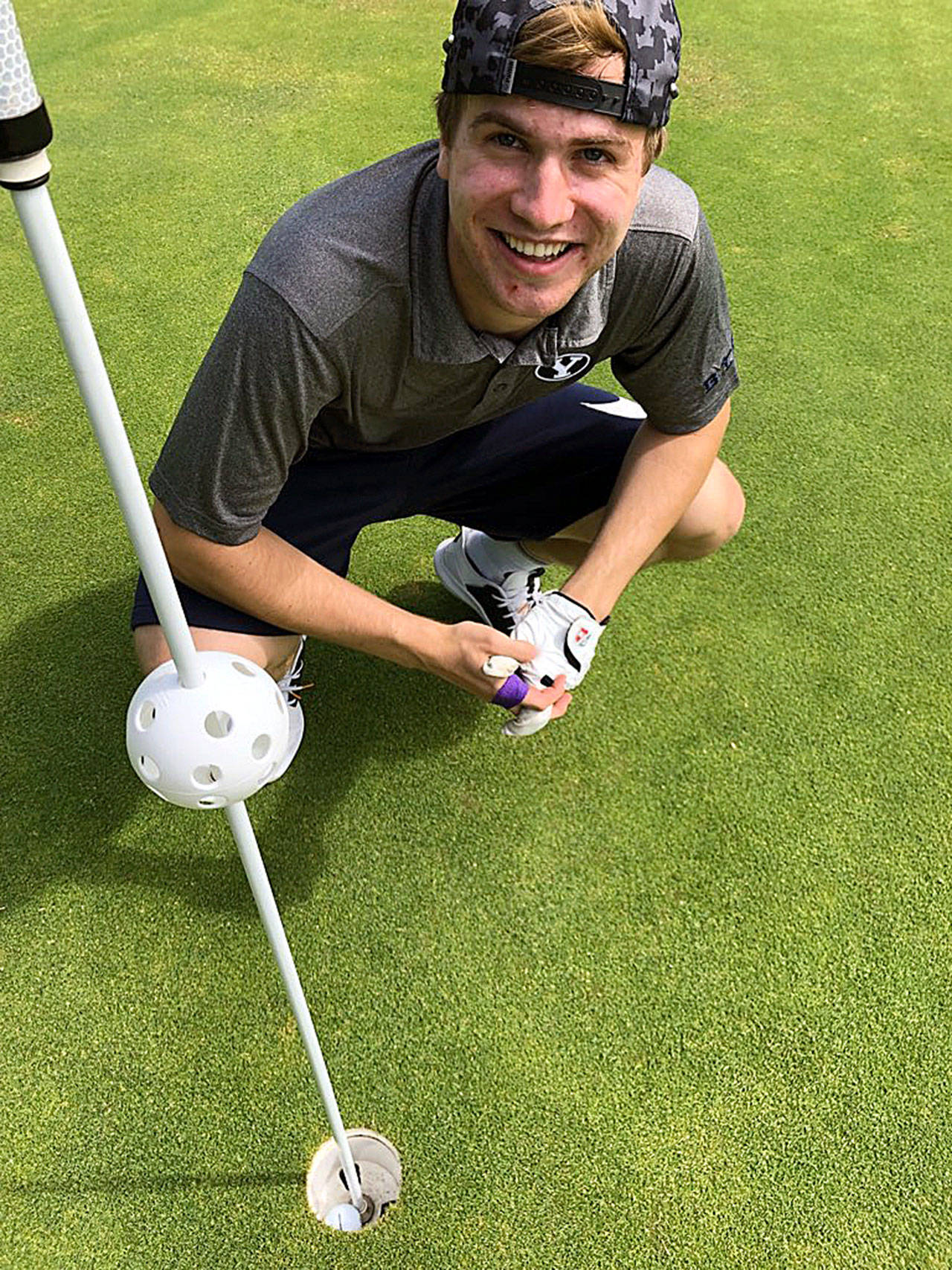 Nick Farrer crouches near the 10th hole after recording an ace on Wednesday, Aug. 14, at Highland Golf Course. (Submitted Photo)