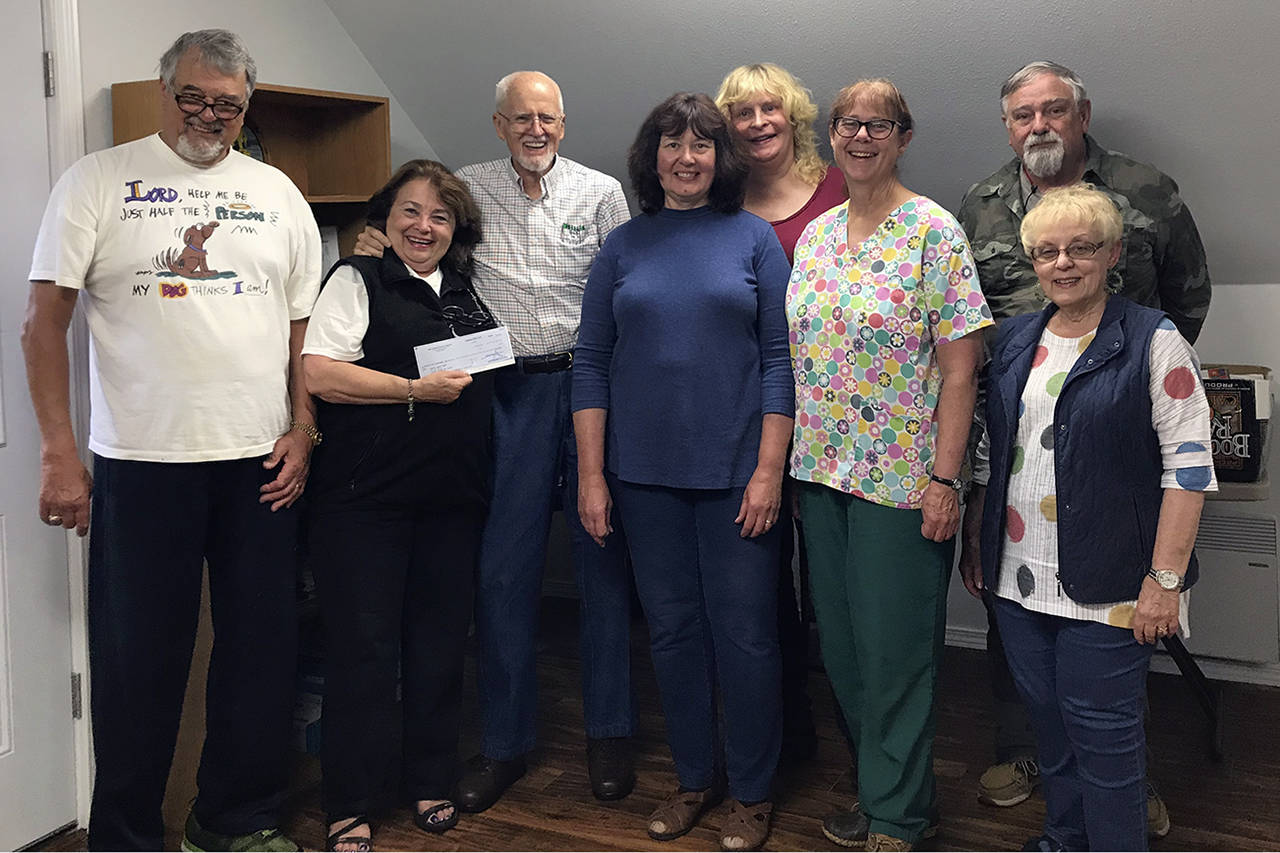 Courtesy photo                                Charlie Utterback, third from left, presents a check for $36,000 to volunteer members of the board of the North Beach PAWS.