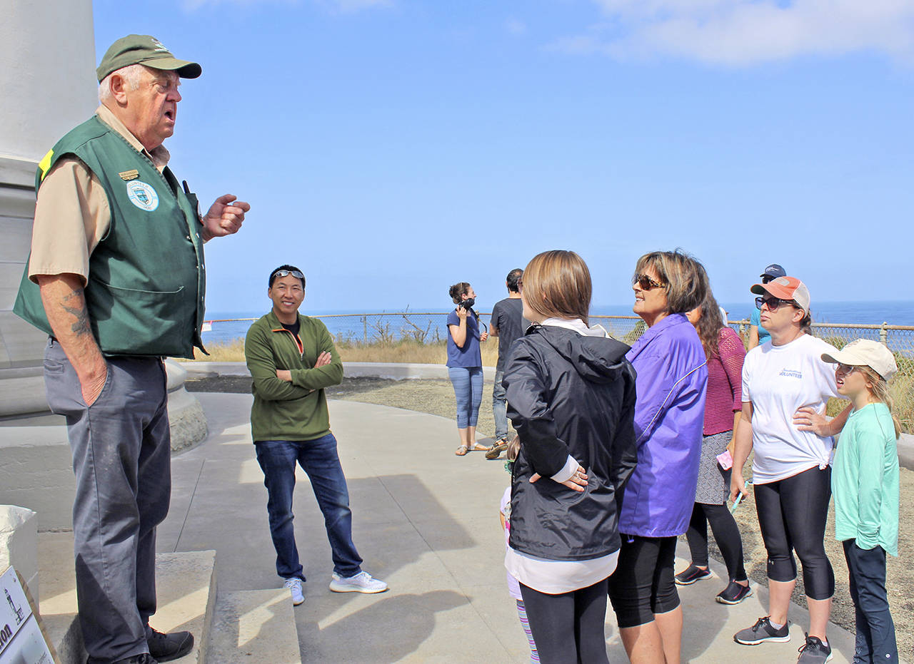 Photos by Patrick Webb                                 Volunteer host Bob Sargent, left, explains the safety rules to the families who were first in line to take a tour when the North Head Lighthouse reopened Aug. 22.