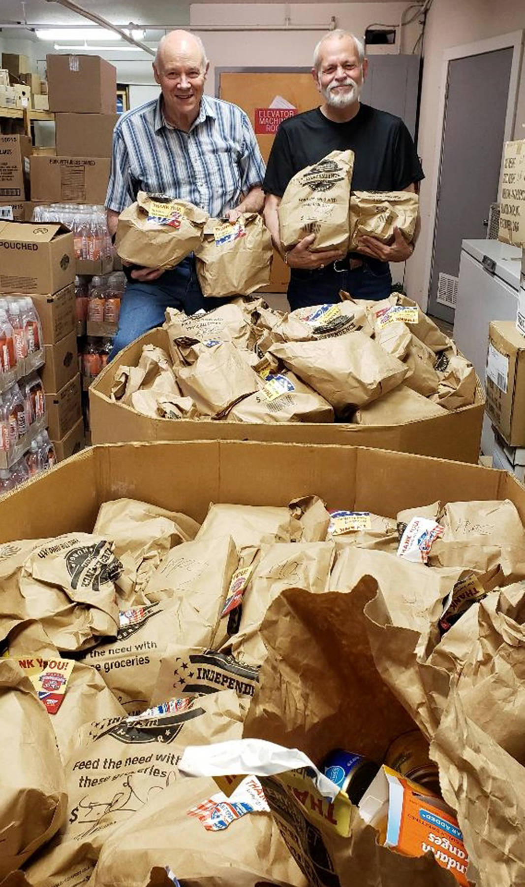 (Photo by Jennifer Chuks) John Dawson, left, and John Beck, volunteers at the Salvation Army Food Bank in Aberdeen, unload some of the bags of groceries recently donated by Grocery Outlet of Aberdeen. More than $6,800 worth of food was donated to local food banks.