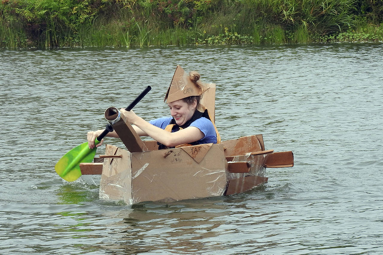photos by Kat Bryant | Grays Harbor News Group                                Kennedy Birley of Lacey frantically paddles her team’s cardboard creation, the Yar, back to shore during Saturday’s event at Oyhut Bay.