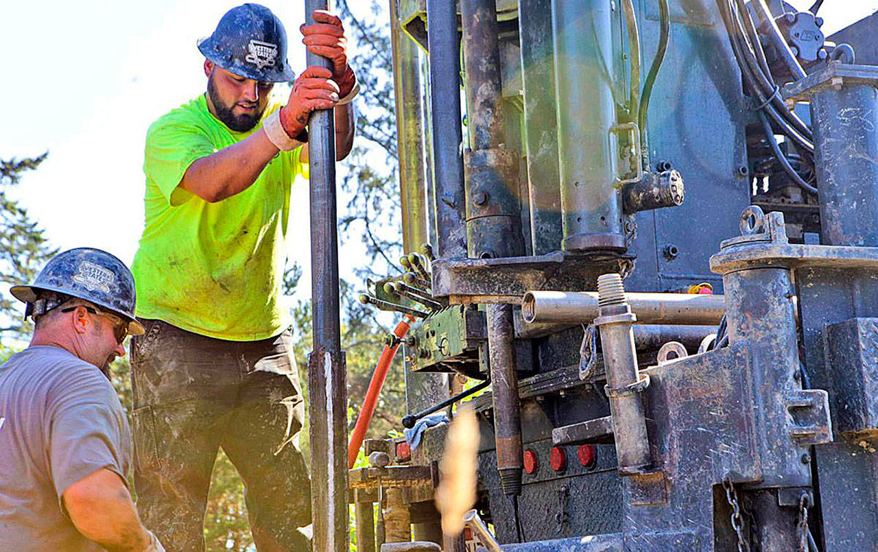 Photo by ASHLEY NERBOVIG | CHINOOK OBSERVER                                Drilling Supervisor Brad Wright stands clear as Driller Sam Moreno sets the drill in place. The men work for Hart Crowser and were in Tokeland to drill out samples of the earth where the Shoalwater Bay Indian Tribe plan to erect a tsunami evacuation tower.