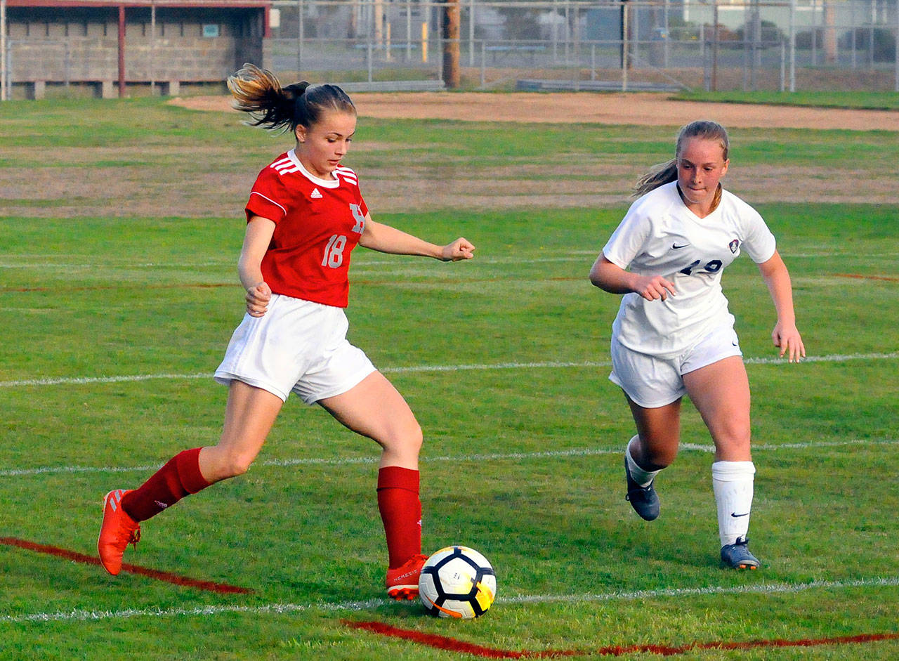 Hoquiam’s Ellie Winkelman, left, protects the ball from King’s Way Christian’s Valerie Knight in the first half on Tuesday at Olympic Stadium. (Hasani Grayson | Grays Harbor News Group)