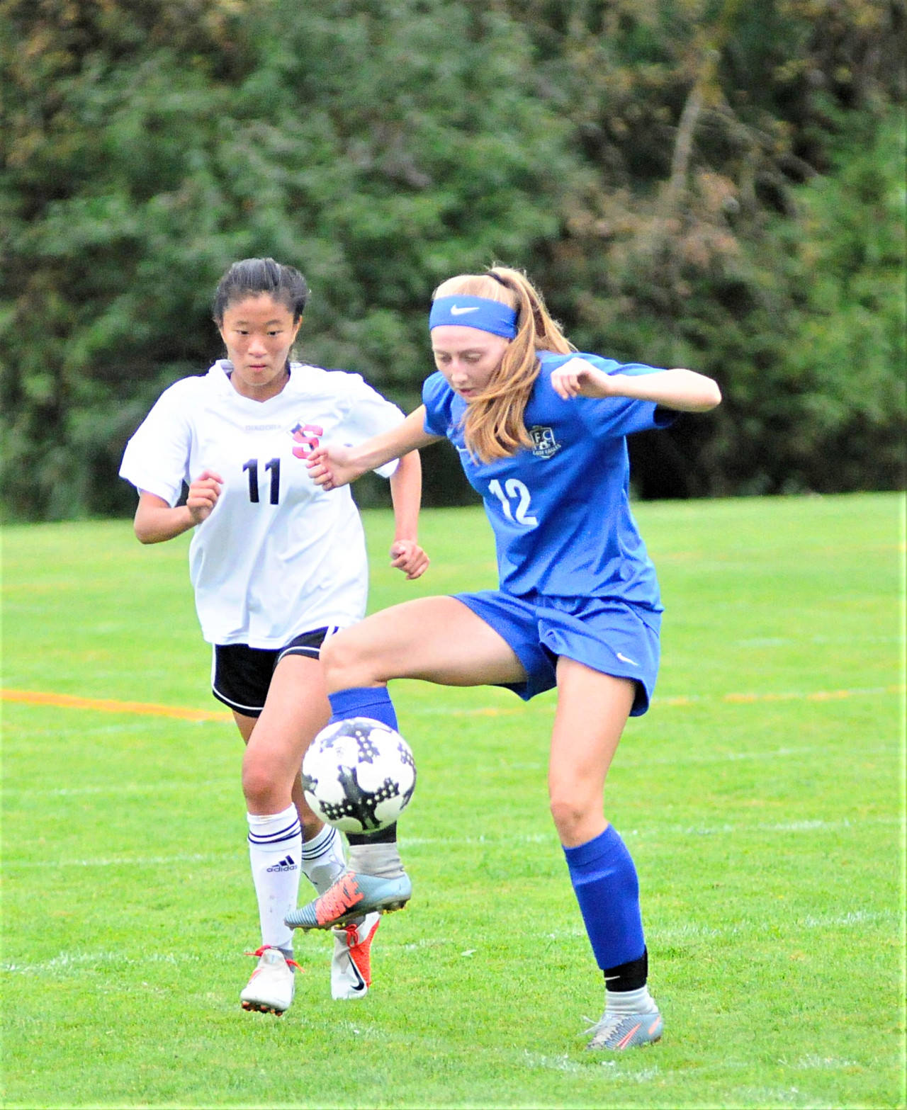 Elma’s Jillian Bieker (12) protects the ball from Shelton’s Mei Ping Vernon in the first half of a game at Davis Field in Elma on Saturday afternoon. (Hasani Grayson | Grays Harbor News Group)