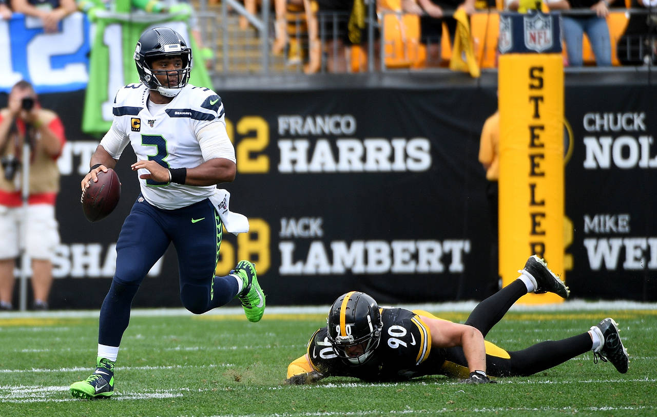 Seattle Seahawks quarterback Russell Wilson (3) scrambles out of the pocket against T.J. Watt (90) of the Pittsburgh Steelers in the second half on Sunday at Heinz Field in Pittsburgh, Pa. (Justin Berl | Getty Images/TNS)