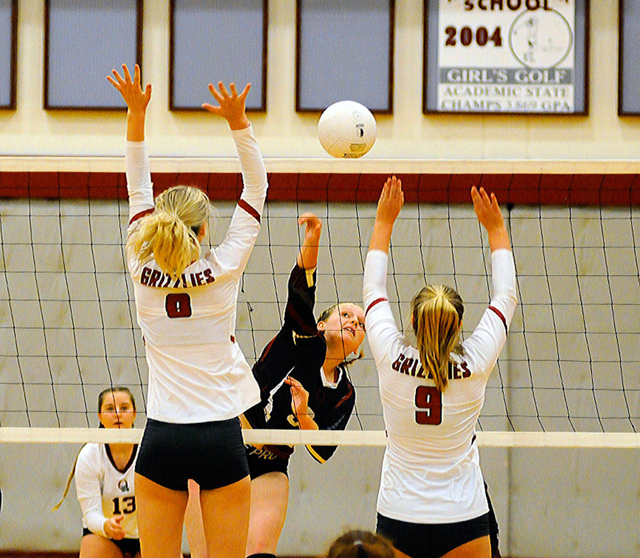 Ocosta’s Layne Martin gets her shot past Hoquiam’s Carsyn Munger and Kamryn Krohn (9) in the first set of a match on Wednesday at Hoquiam High School. (Hasani Grayson | Grays Harbor News Group)