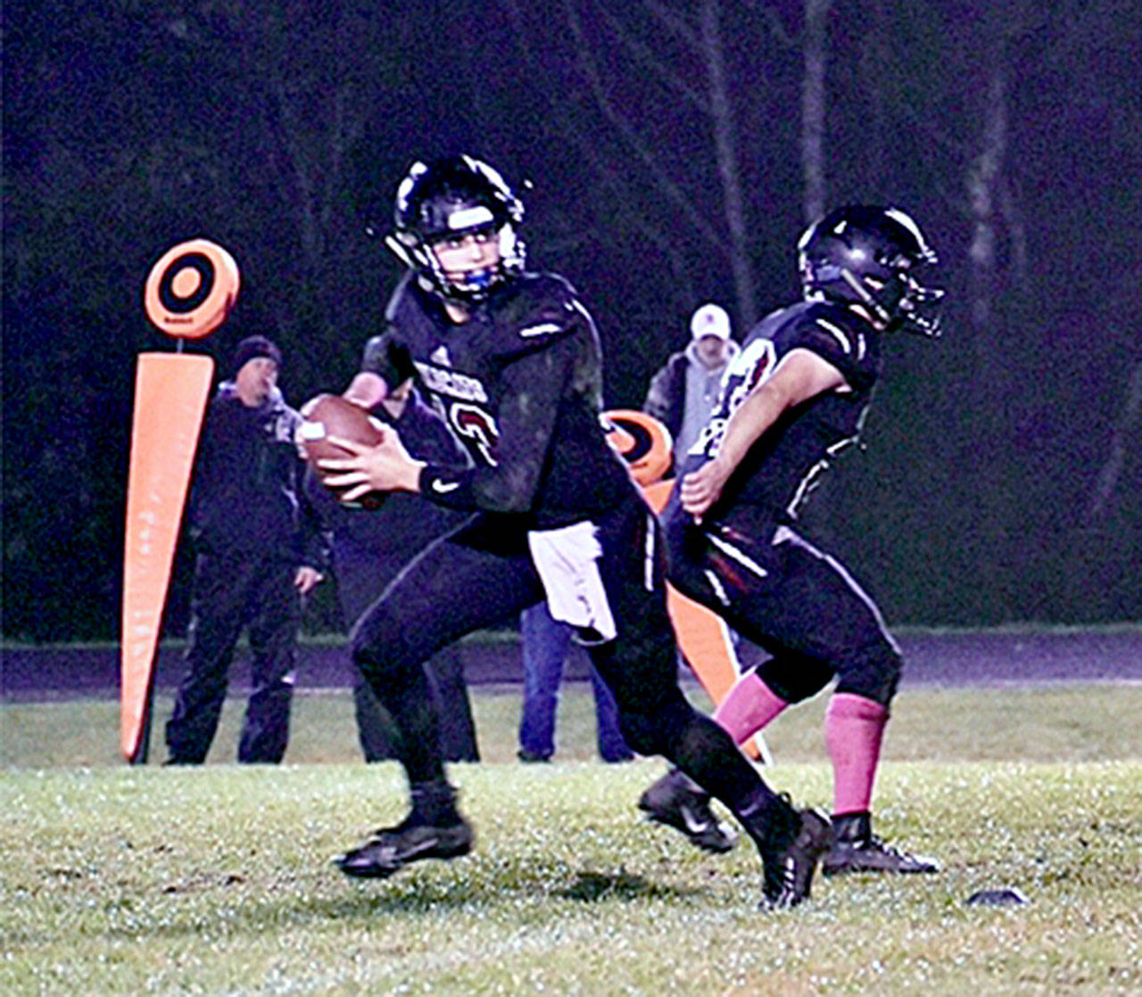 Ocosta quarterback Cole Hatton, left, drops back to pass during last week’s victory over Raymond. The undefeated Wildcats face Pe Ell-Willapa Valley on Friday for first place in the 2B Pacific League’s Coastal division. (Submitted photo)