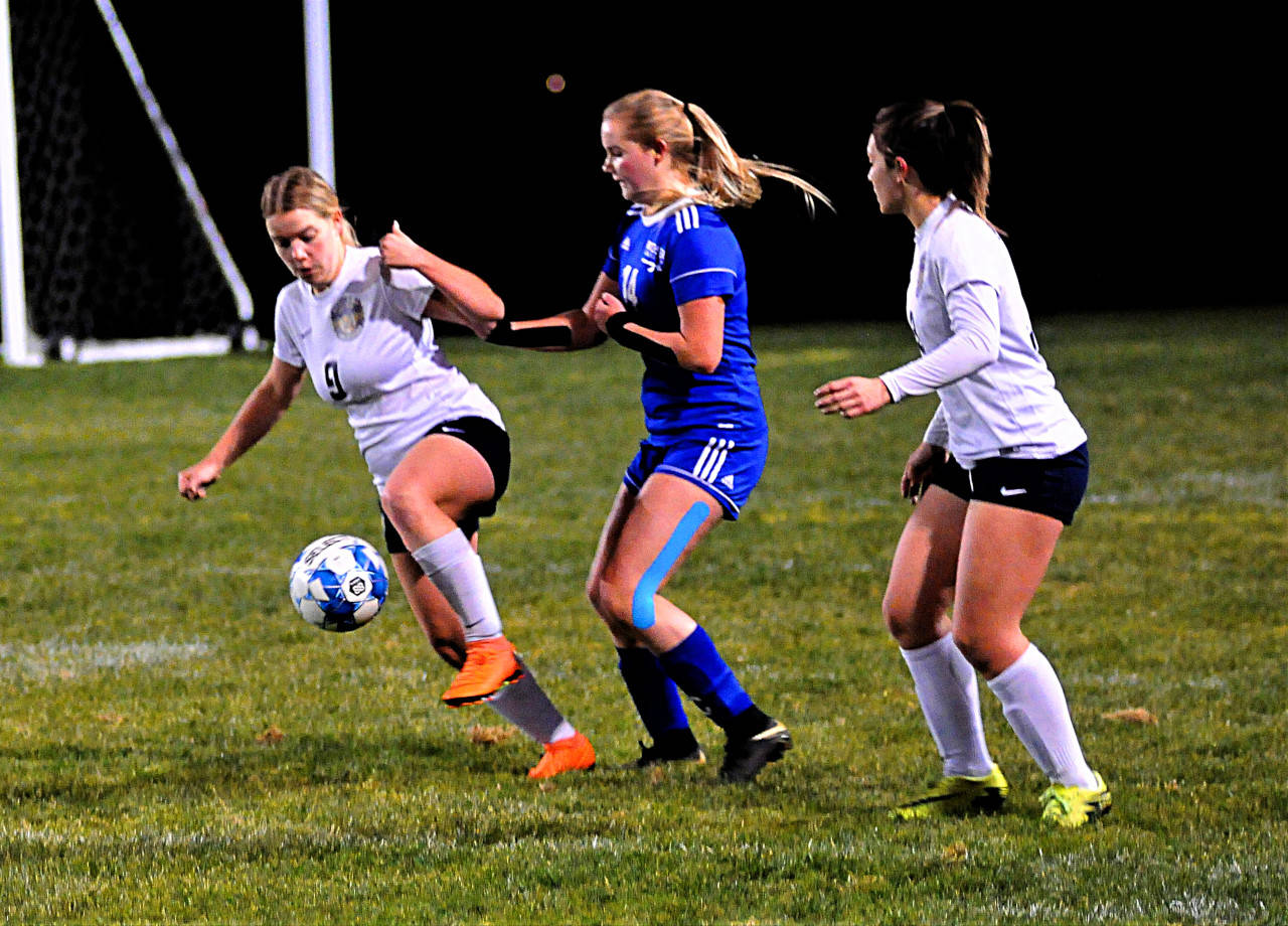 Aberdeen’s Abbie Bradt settles a bouncing ball around midfield while defended by Rochester’s Payton Pekola, center, in the first half of a match at Rochester on Tuesday. (Hasani Grayson | Grays Harbor News Group)