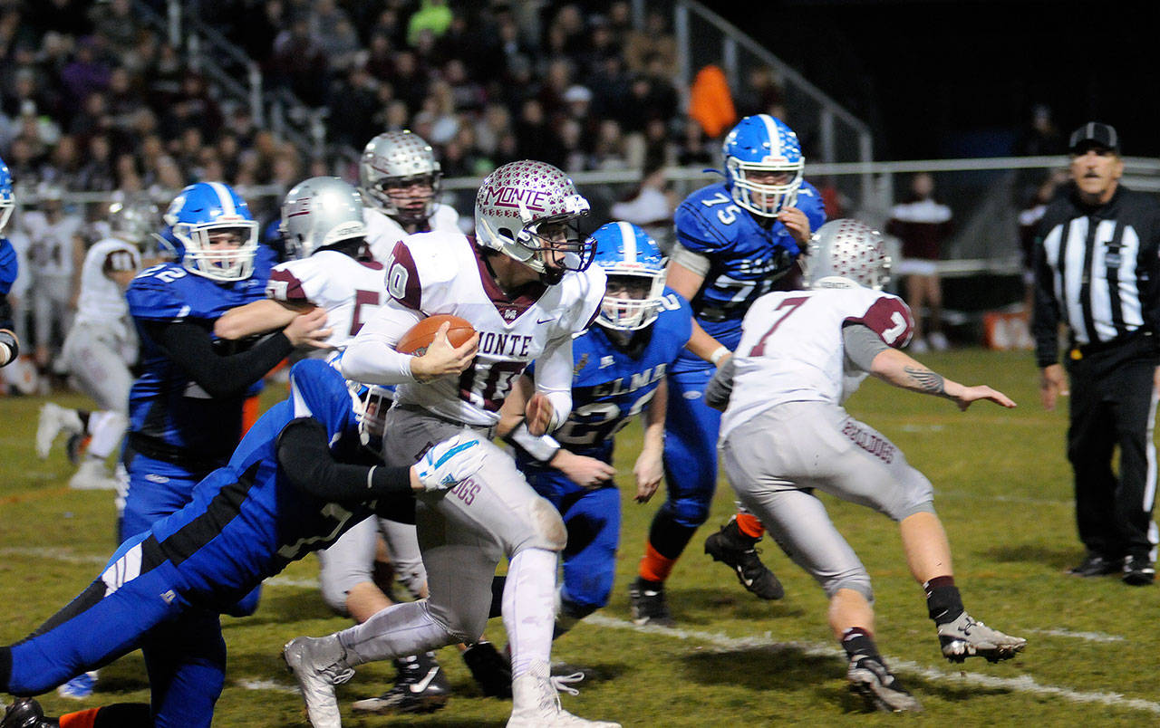 Montesano quarterback Trace Ridgway tries to break away from a tackle by Noah Huttula in the first quarter in Elma on Friday. Ridgway ran for a team-leading 123 yards in Monte’s 49-7 win over the Eagles. (Hasani Grayson | Grays Harbor News Group)