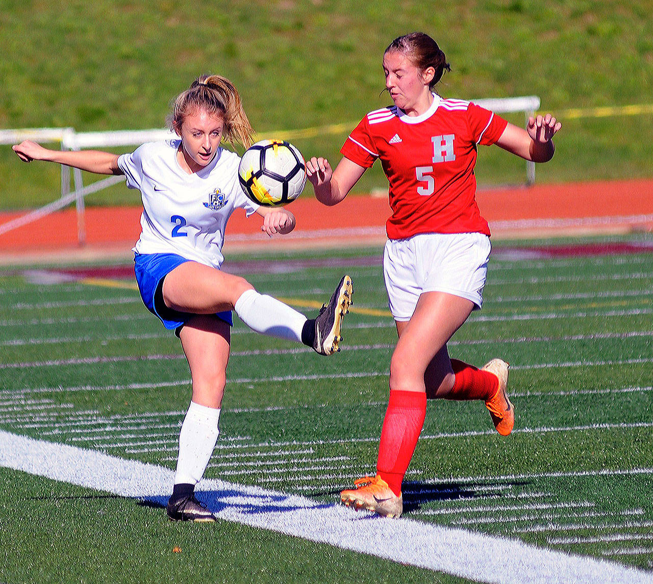 Elma’s Chloe Clark, left, clears the ball away from Hoquiam’s Emily Daniels in the first half of a district play-in game on Saturday in Montesano. (Hasani Grayson | Grays Harbor News Group)
