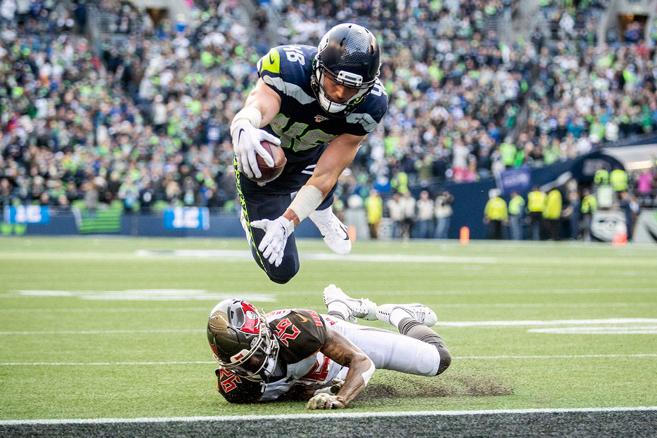 Seattle Seahawks tight end Jacob Hollister dives over Tampa Bay Buccaneers defensive back Sean Murphy-Bunting and the goal line for his first career score, a 1-yard touchdown in the second quarter, on Sunday, Nov. 3, 2019 at CenturyLink Field in Seattle, Wash. (Mike Siegel/Seattle Times/TNS)