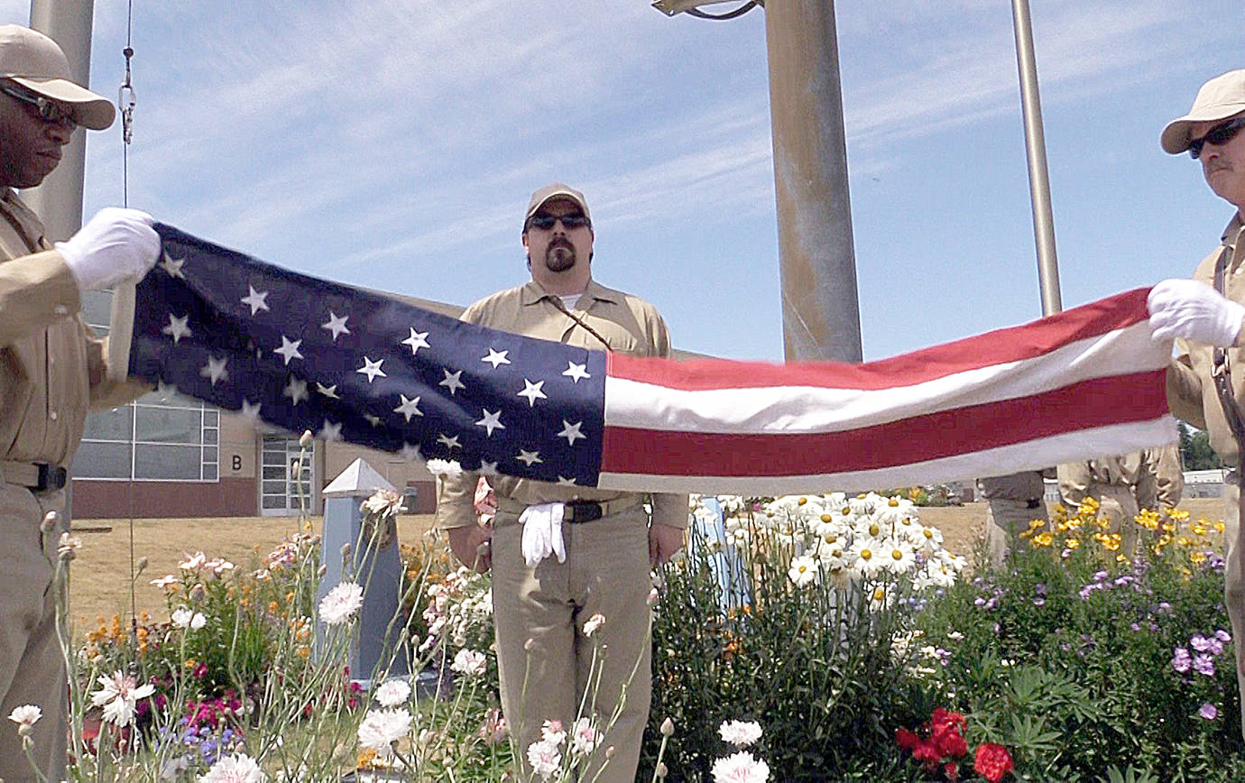 DEPARTMENT OF CORRECTIONS FILE PHOTO                                Incarcerated veterans unfold the American flag during a flag-raising ceremony at Stafford Creek Corrections Center.