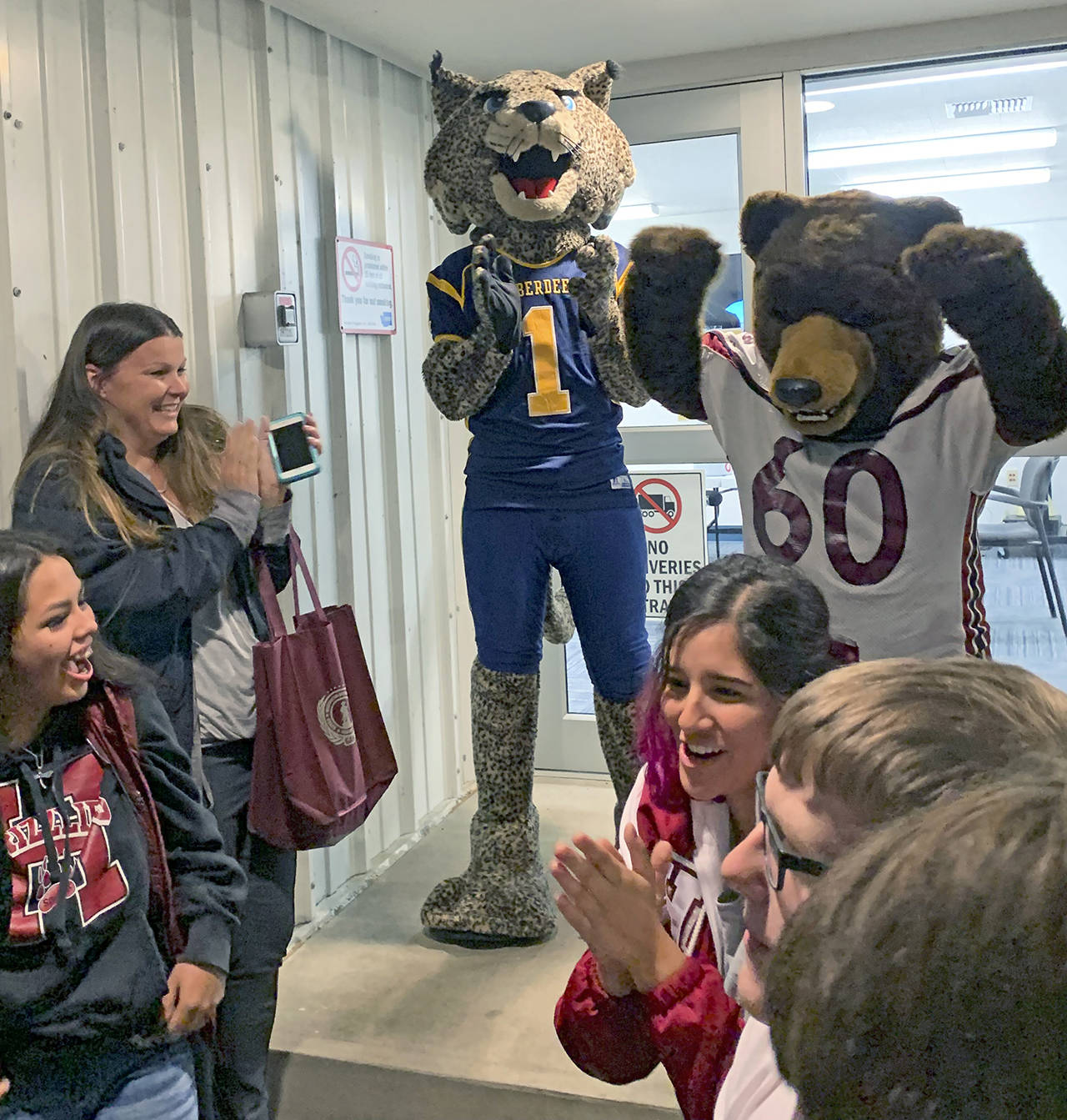 Kat Bryant | Grays Harbor News Group                                Aberdeen’s Bobcat mascot applauds Hoquiam’s Grizzly on Tuesday evening as they break the news that Hoquiam won this year’s Food Ball competition.