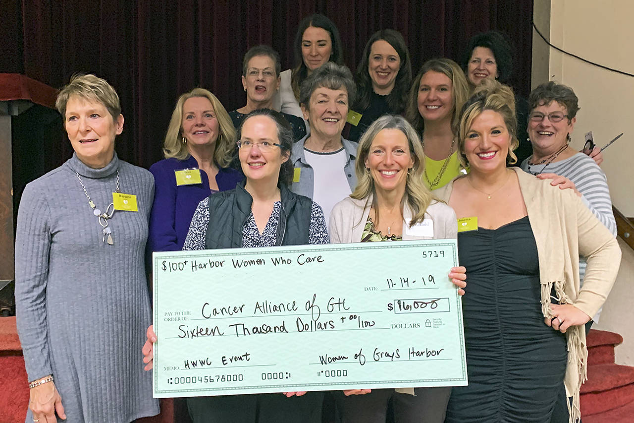 The 10 core members of 100+ Harbor Women Who Care present the ceremonial check to Dr. Juliette Erickson and Jan Dahl of the Cancer Alliance of Grays Harbor.
