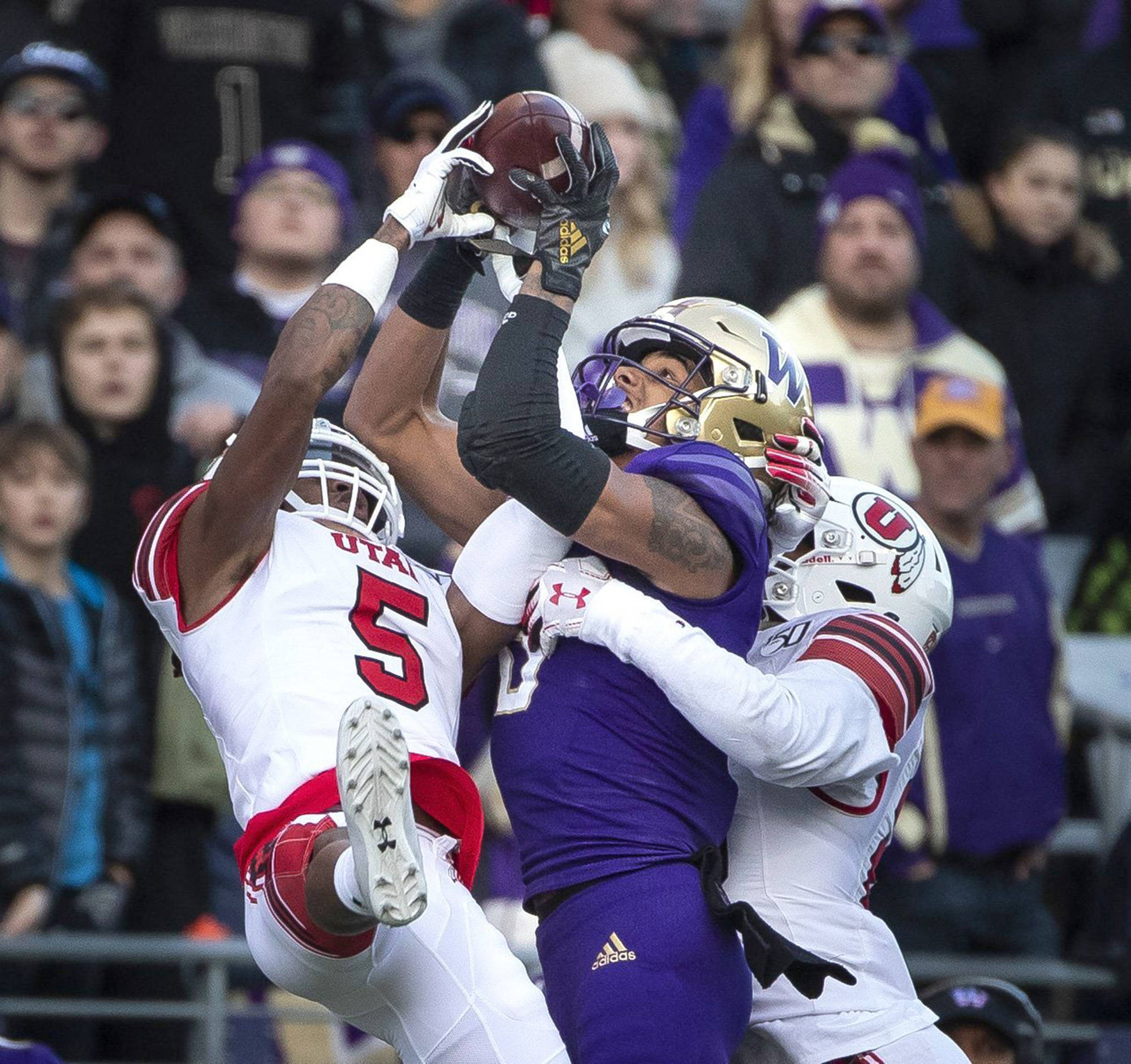 Dean Rutz | Seattle Times                                Washington wide receiver Marquis Spiker, middle, can’t pull in a long pass while defended by Utah’s Tareke Lewis (5) at Husky Stadium in Seattle on Saturday, Nov. 2.