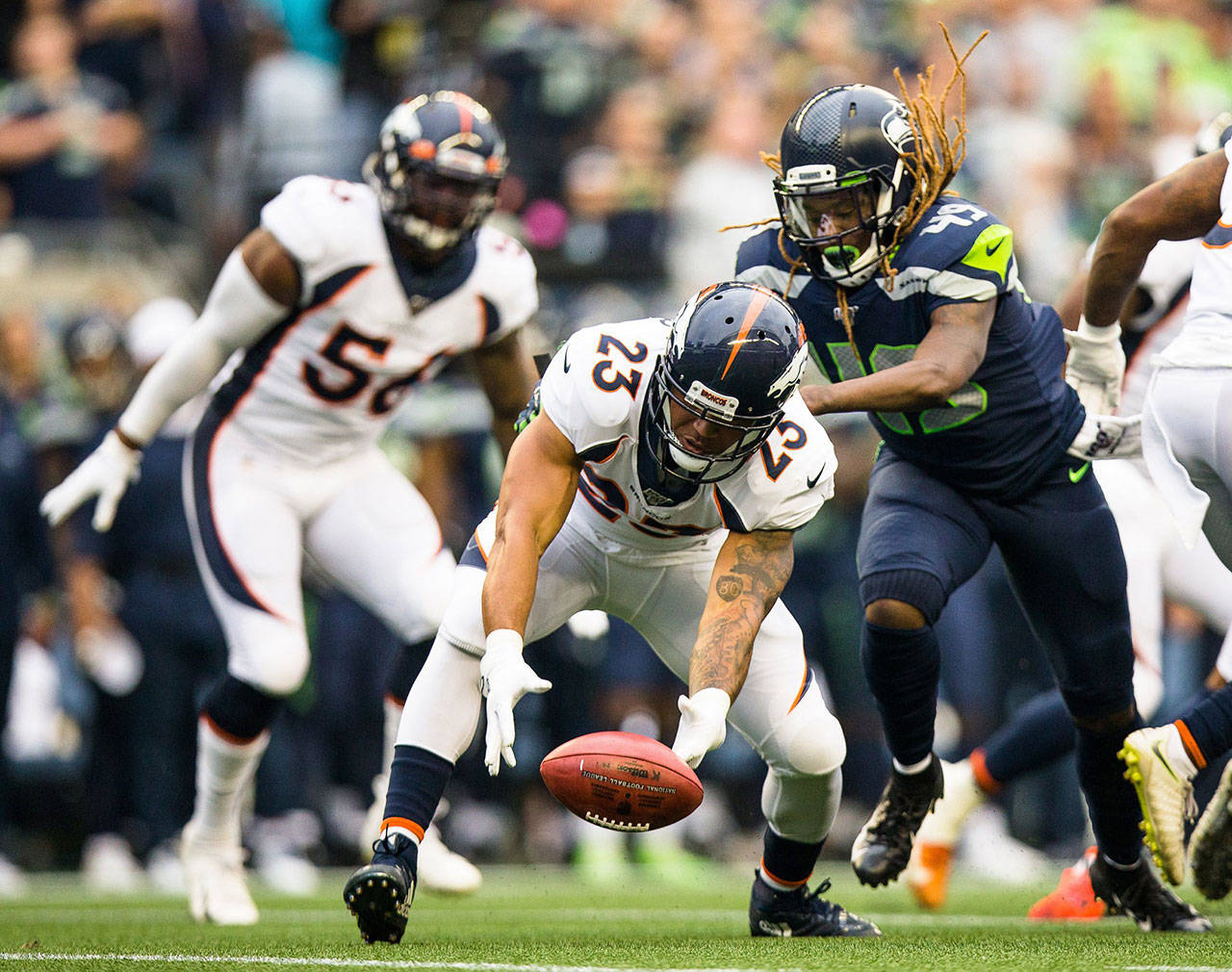 Seattle Seahawks linebacker Shaquem Griffin, right, hits Denver Broncos running back Devontae Booker (23) during a preseason game at Century Link Field in Seattle on Thursday, Aug. 8, 2019. (Rebekah Welch/Seattle Times/TNS)