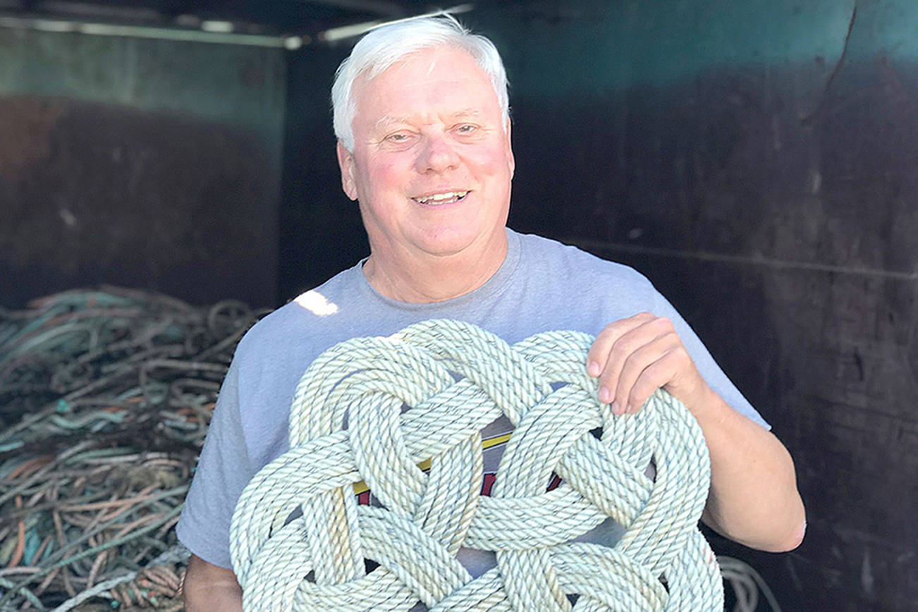 Former Astoria fisherman Greg Neitzel with one of his chafing mats woven from line recycled by the Westport fleet. (Photo courtesy of Molly Bold | Westport Marina)