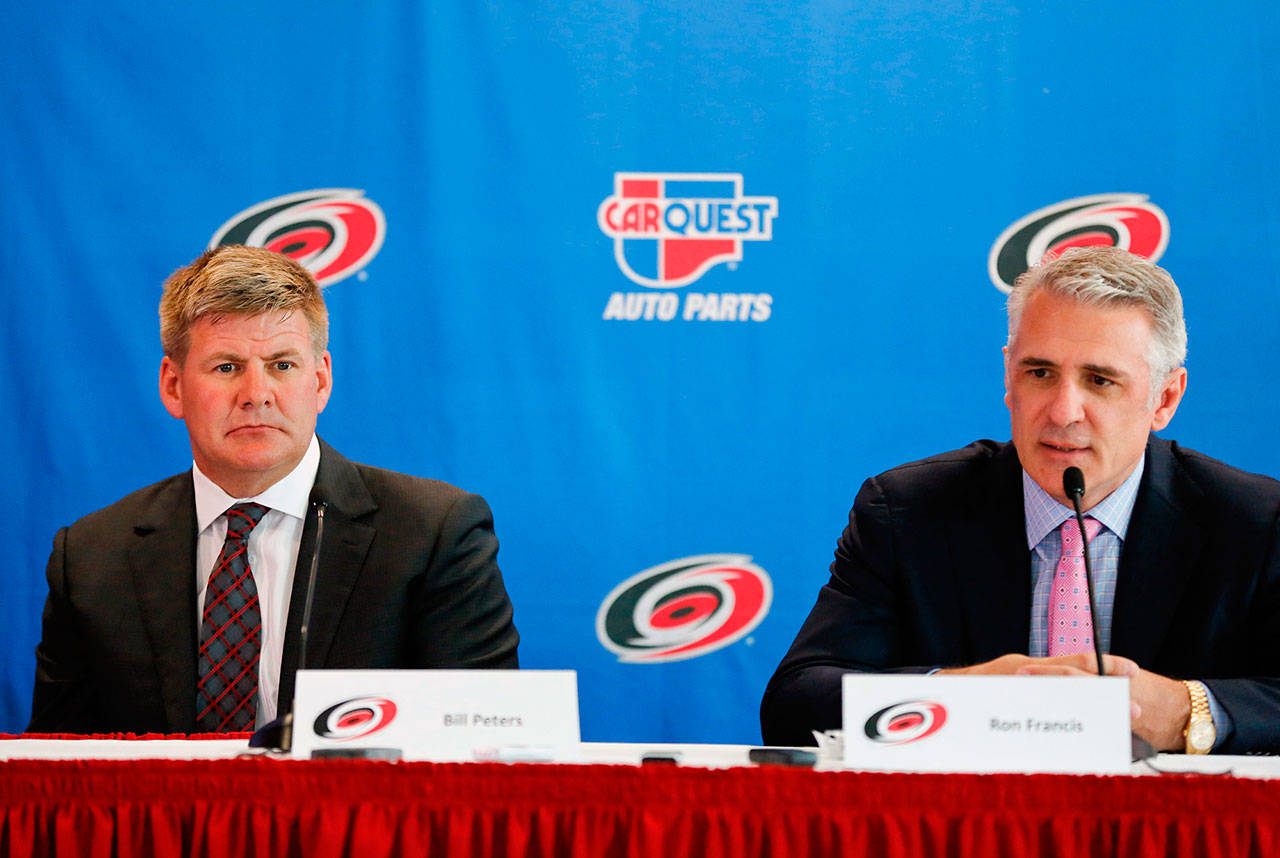 Former Carolina Hurricanes head coach Bill Peters, left, and general manager Ron Francis speak to the media during Peters’ introductory news conference at PNC Arena in Raleigh, N.C., on June 20, 2014. Francis, now the NHL Seattle GM, has been scrutinized for his handling of player abuse allegations against Peters while the two were in Carolina. (Jill Knight/Raleigh News & Observer/TNS)                                Former Carolina Hurricanes head coach Bill Peters, left, and general manager Ron Francis speak to the media during Peters’ introductory news conference at PNC Arena in Raleigh, N.C., on June 20, 2014. Francis, now the NHL Seattle GM, has been scrutinized for his handling of player abuse allegations against Peters while the two were in Carolina. (Jill Knight/Raleigh News & Observer/TNS)