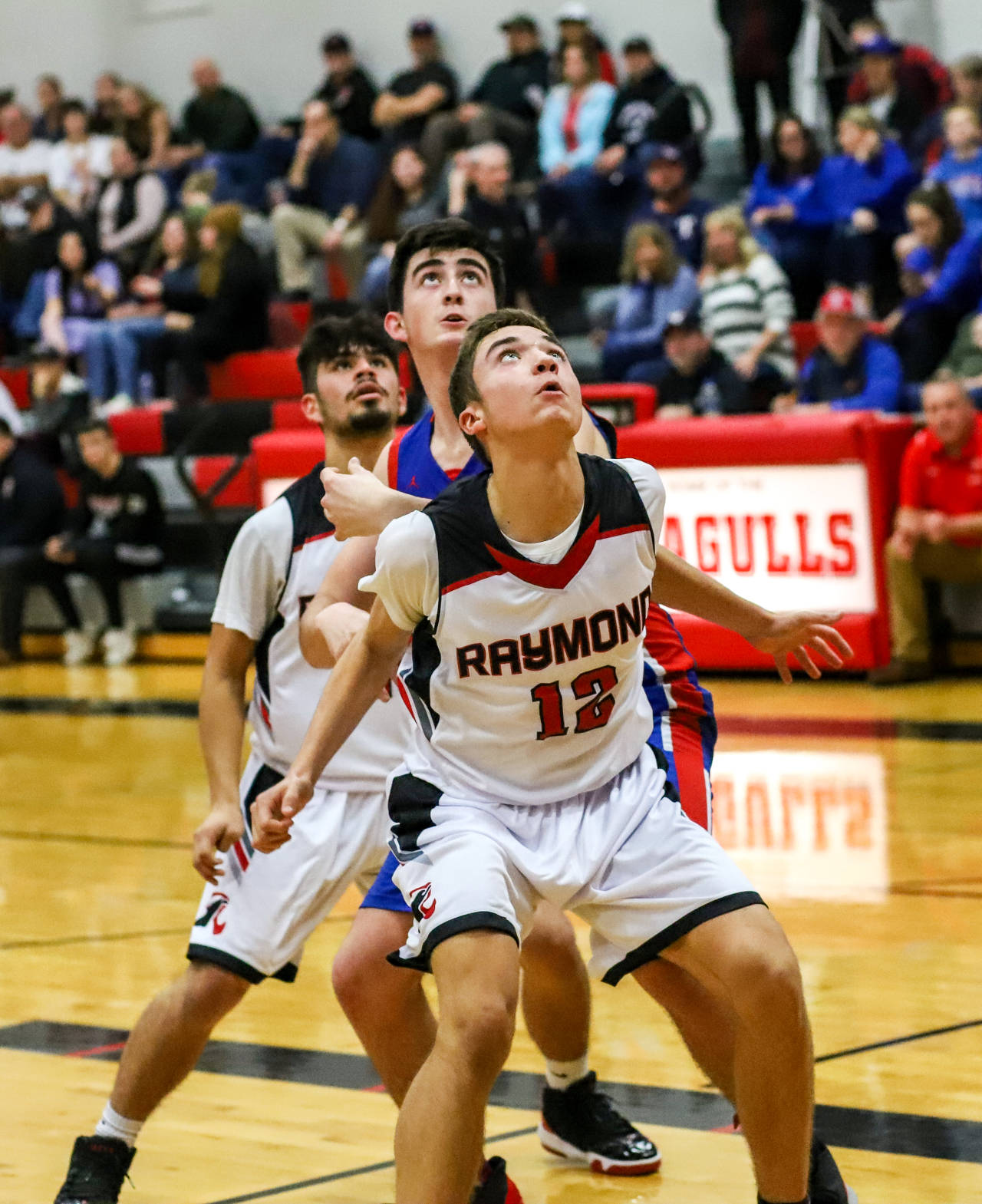 Raymond’s Trey Seydel, foreground, and Joseph Villalpando box out Willapa Valley’s Logan Walker during the Vikings’ 71-50 season-opening victory on Wednesday in Raymond. (Photo by Larry Bale)