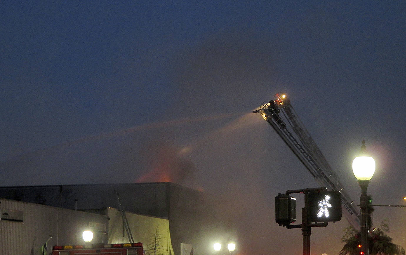COURTESY DANIEL HOEFS                                Flames are visible from the roof of a building at 115 W. Heron St. early Saturday morning. The early morning fire gutted the building, which formerly housed C&C Motor Sports on the ground floor and the Revival Grays Harbor on the second.
