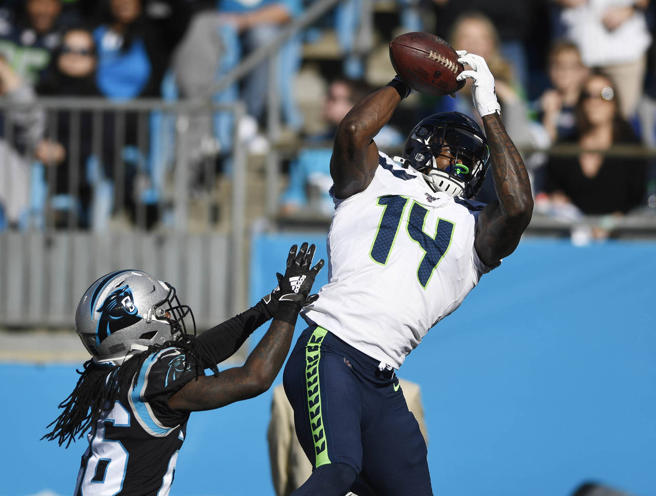 Seattle Seahawks wide receiver D.K. Metcalf (14) reaches up for a touchdown reception past Carolina Panthers cornerback Donte Jackson (26) during the first half at Bank of America Stadium on Sunday. (David T. Foster III/Charlotte Observer/TNS)