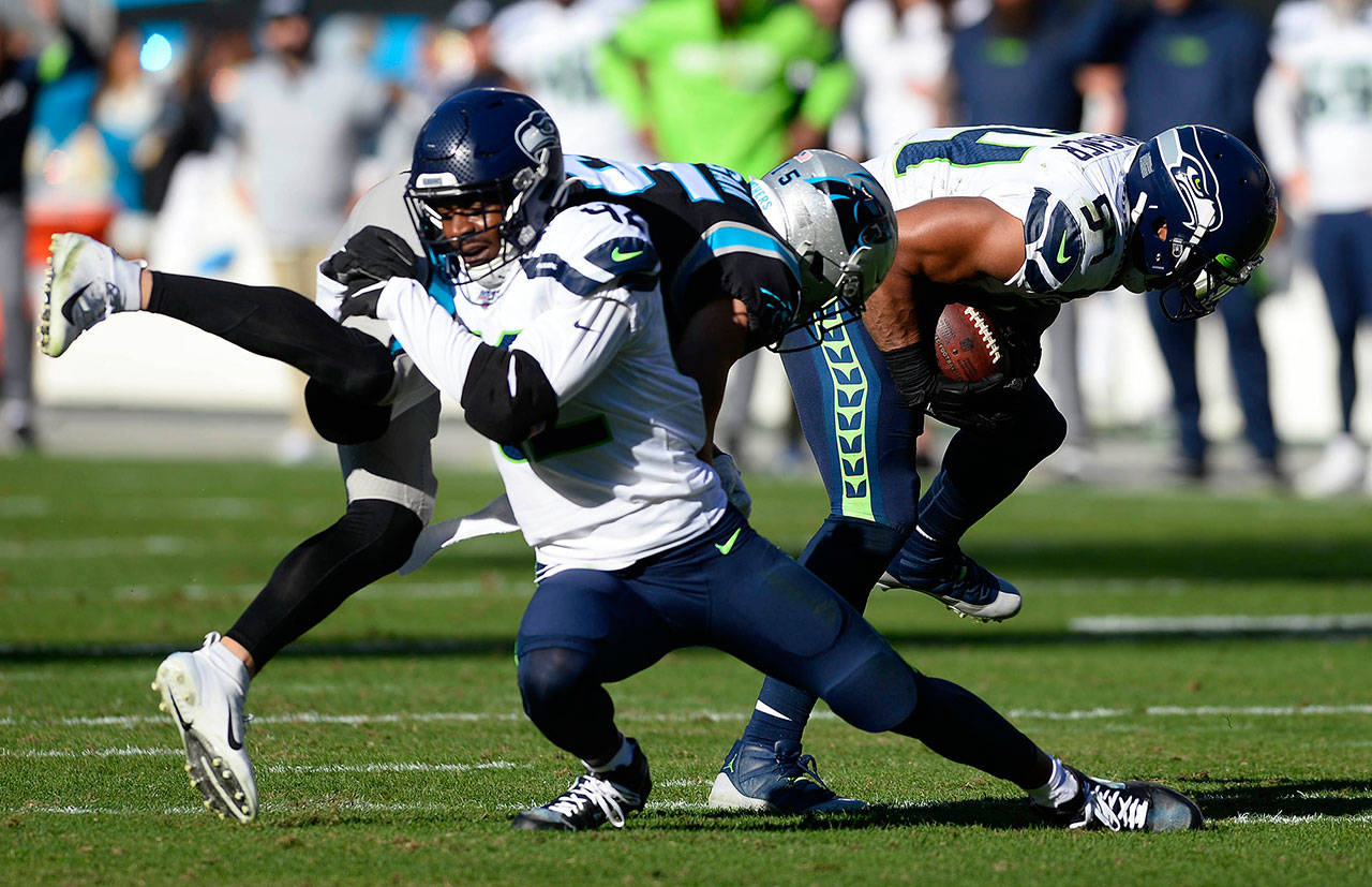 Seattle Seahawks middle linebacker Bobby Wagner (54) intercepts a pass intended for Carolina Panthers wide receiver Chris Hogan (15) as defensive back Lano Hill (42) blocks him during the first half at Bank of America Stadium on Sunday, Dec. 15, 2019. (David T. Foster III/Charlotte Observer/TNS)
