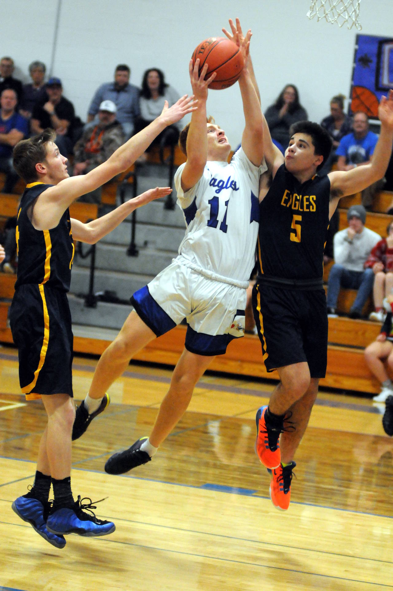 Elma’s Nick Church (11) is met at the basket by Pope John Paul’s Francis Pettis (5) and Spencer Humberd during Elma’s 73-45 victory on Monday in Elma. (Ryan Sparks | Grays Harbor News Group)