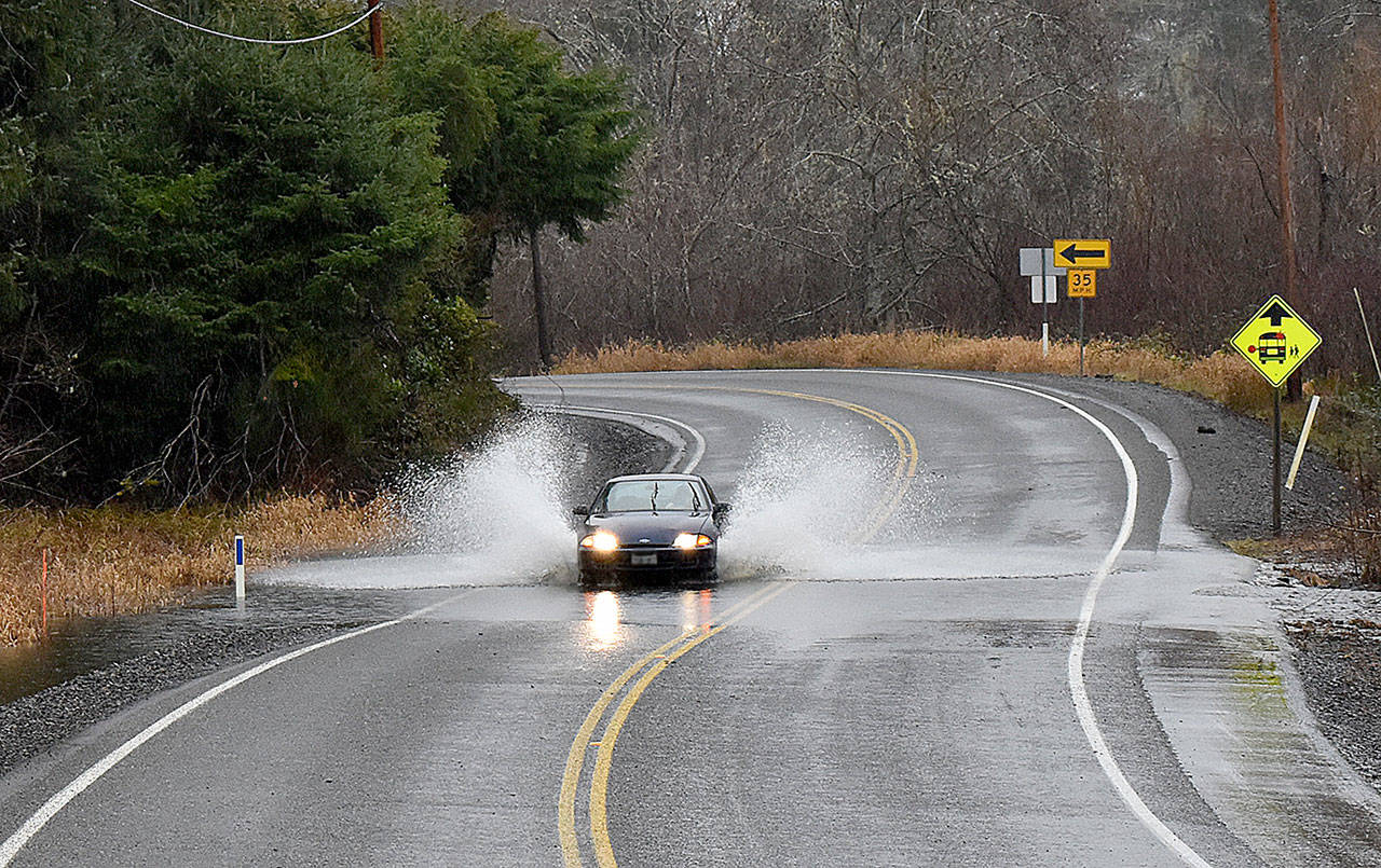 DAN HAMMOCK | GRAYS HARBOR NEWS GROUP                                A car plows through water crossing the roadway a few miles up the Wishkah north of Aberdeen Thursday. Heavy rains and high tides caused some localized flooding in the region, and a flood watch remains in effect in Grays Harbor County through 10 p.m. Sunday.