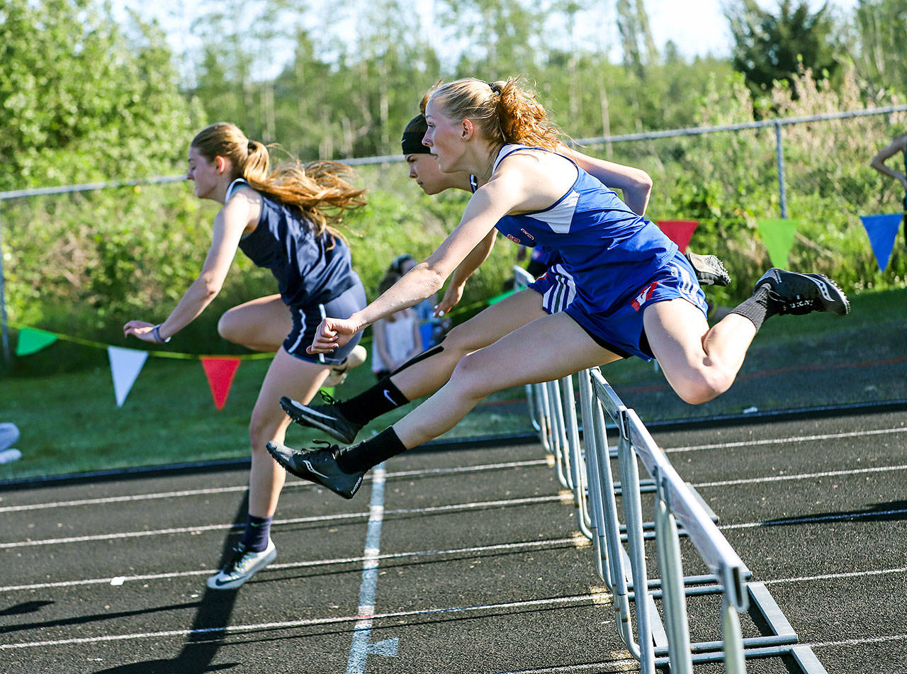 Ilwaco’s Elizabeth McMullen, left, leads Willapa Valley’s Hannah Cook, foreground, and Brooke Friese during the girls 100-meter hurdles at the Pacific League Sub-District Finals on Friday, May 10. (Photo by Larry Bale)