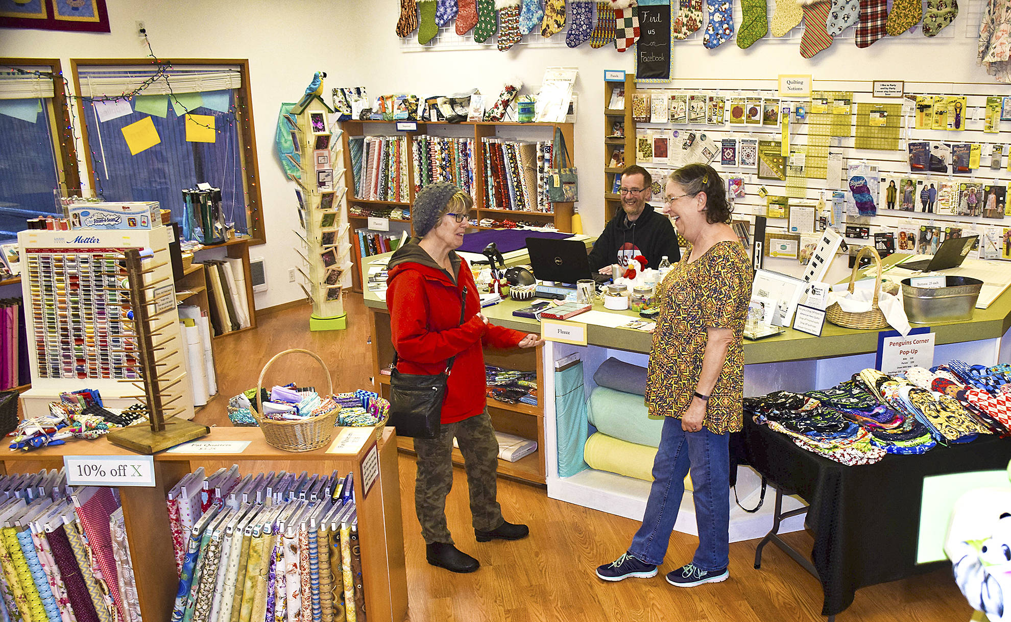 Photo by Scott D. Johnston                                The new owners of Beach Tyme Fabric & Craft Supply in Ocean Shores, Chuck and Gail Anderson (center and right) chat with a new customer, Kelly Osness of Ocean Shores, at the store located at 873 Pt. Brown Ave. NW.