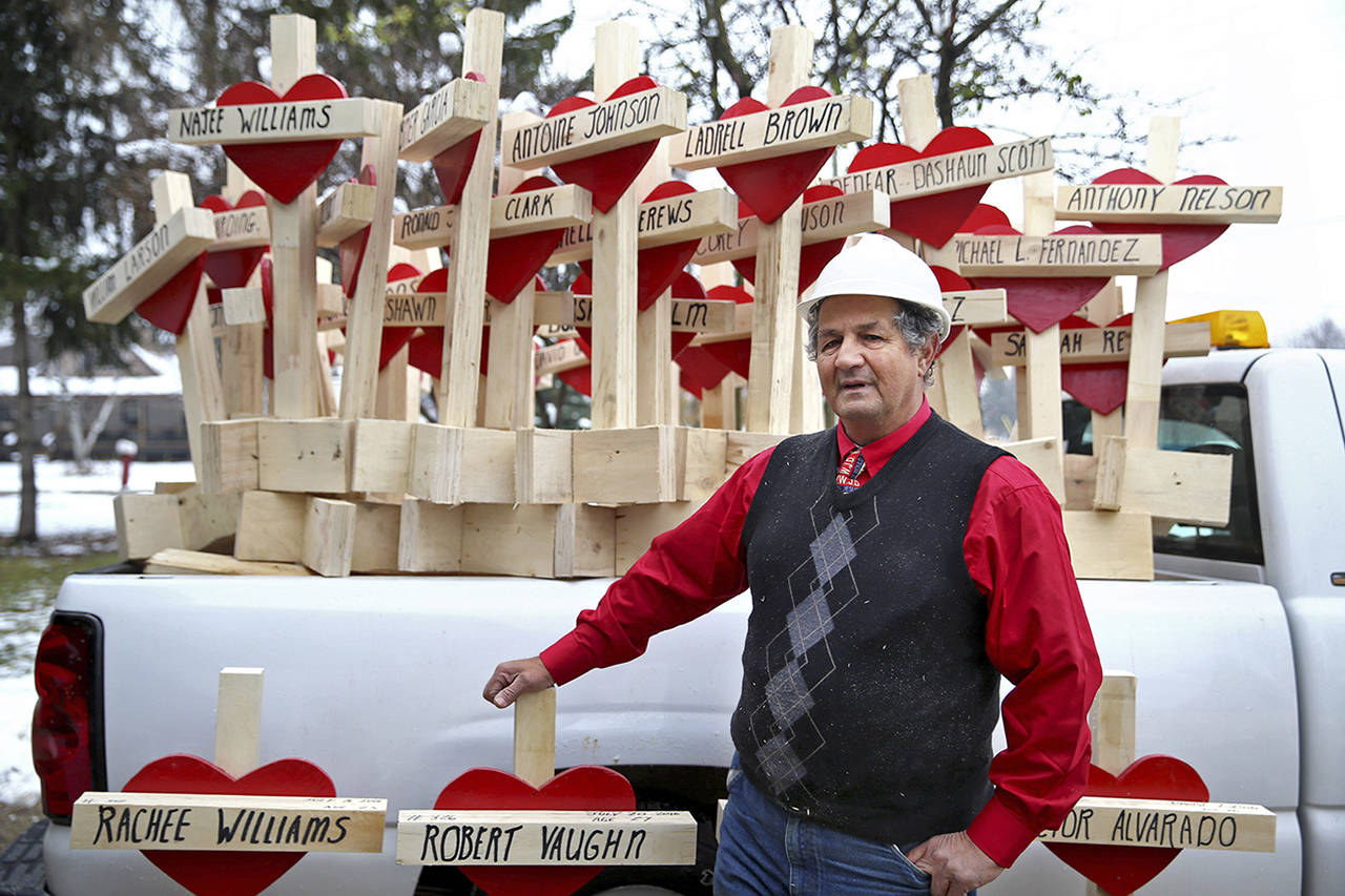 Stacey Wescott | Chicago Tribune                                Greg Zanis stands outside his home in Aurora, Illinois, with some of the crosses he made in 2016 to honor murder victims in Chicago that year.