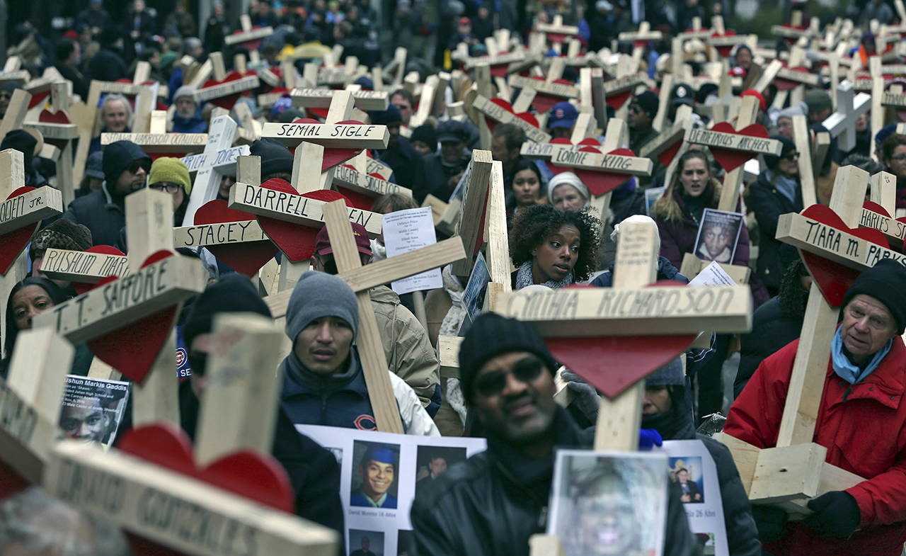 Abel Uribe | Chicago Tribune                                On Dec. 31, 2016, family members, friends and volunteers helped carry over 700 crosses along Michigan Avenue in Chicago in honor of those killed in the city that year.