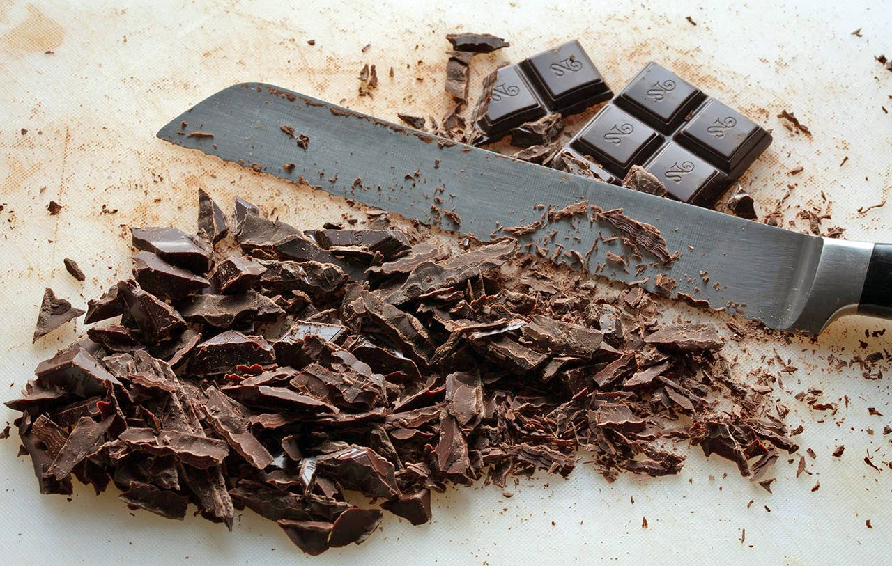 Photos by E. Jason Wambsgans | Chicago Tribune                                Use a serrated knife to shave the chocolate bar into thin pieces. This will make the chocolate melt more quickly when you pour the hot cream over it.