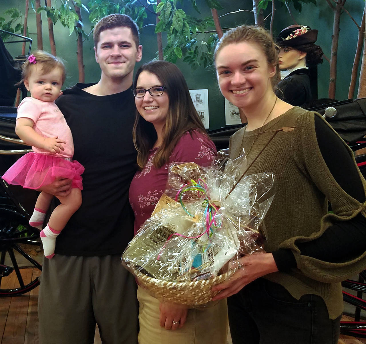 Mary Cooley, right, gives a gift basket to Anastasia Becraft, the museum’s 75,000th visitor, who was there Sept. 21 with her husband, Raymond, and their daughter, Loretta.