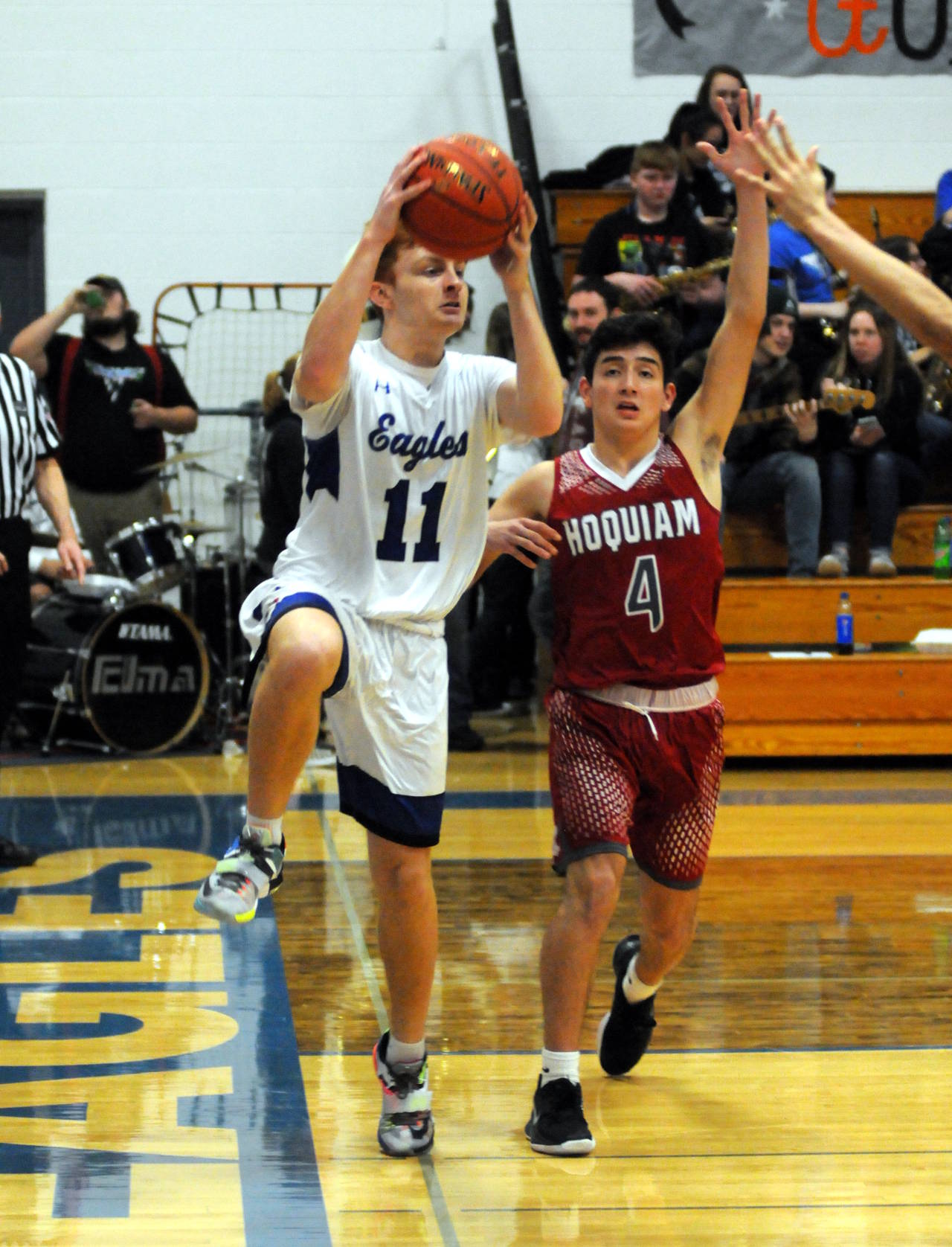 Elma’s Nick Church drives the baseline against Hoquiam’s Abe Morales during the Grizzlies’ 52-50 victory on Friday in Elma. (Ryan Sparks | Grays Harbor News Group)