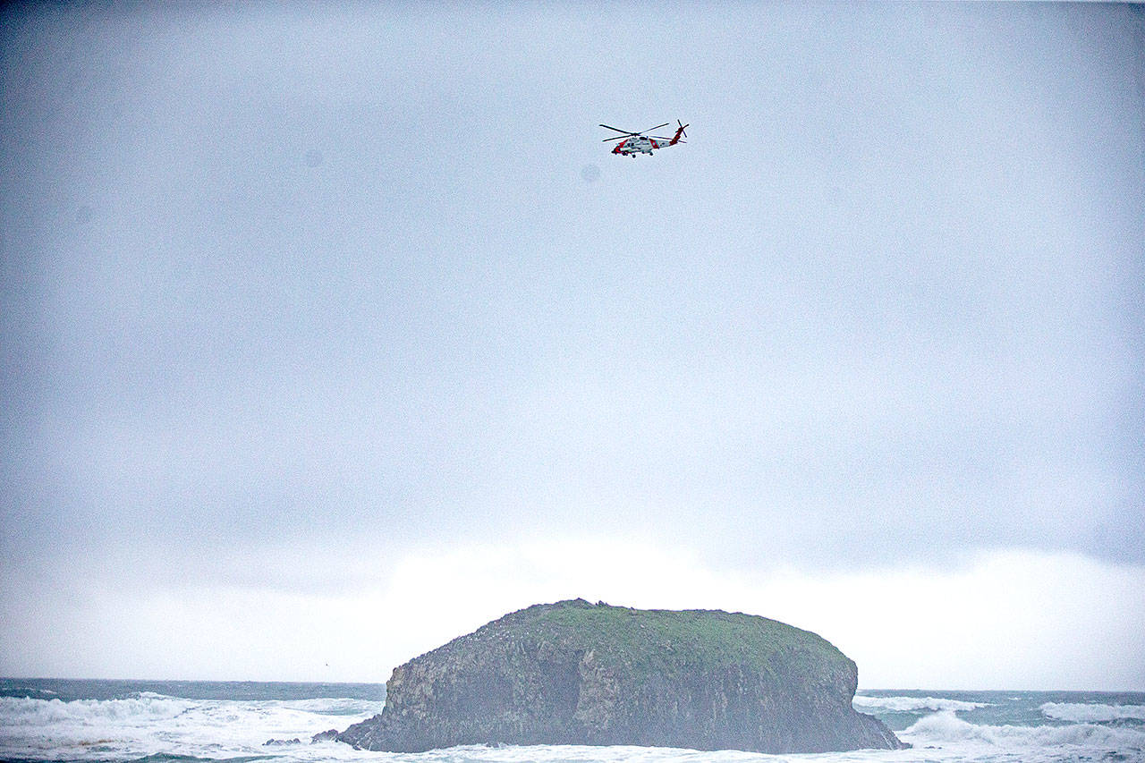 A Coast Guard helicopter circles over Falcon Cove Beach in Oregon, where a family was swept into the ocean Saturday. (Mark Graves/The Oregonian)
