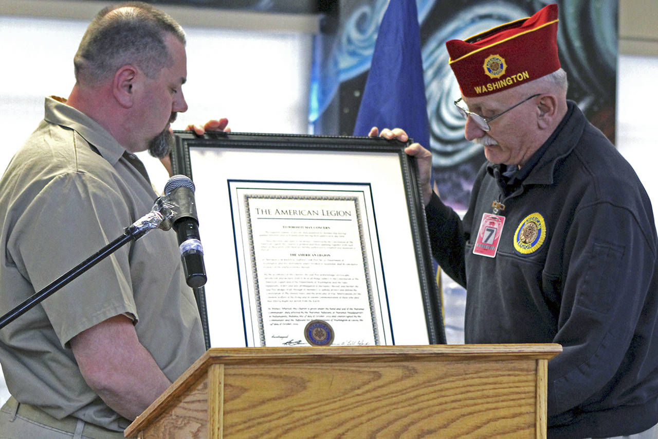Photos by Rachel Friederich                                David Hodgeboom, right, presents an incarcerated veteran at Stafford Creek Corrections Center with a framed charter for the prison’s American Legion post. Hodgeboom is a U.S. Army veteran and serves on the American Legion National Executive Committee.