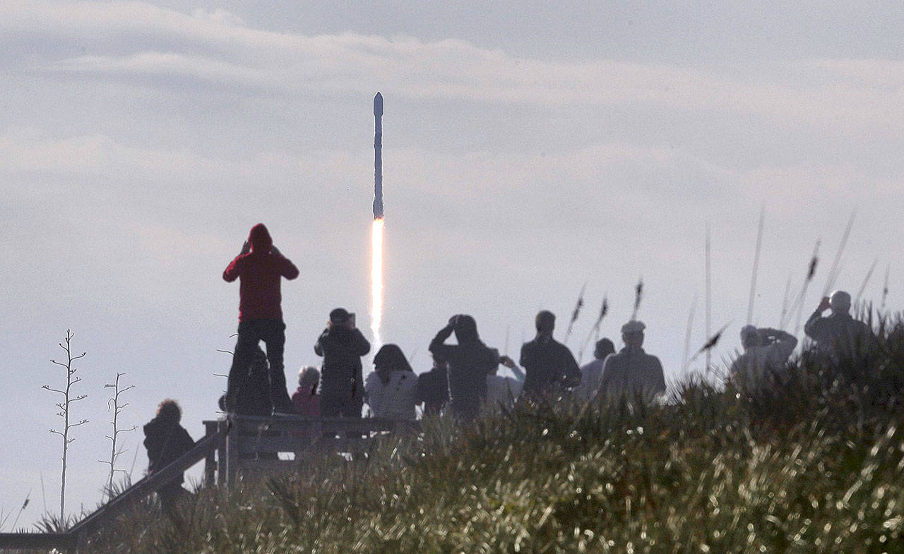 In this view from Playalinda Beach at Canaveral National Seashore in Florida, visitors watch a SpaceX Falcon 9 rocket launch from Cape Canaveral Air Force Station carrying 60 Starlink satellites Wednesday. It’s the fourth launch of satellites in the SpaceX Starlink mission. (Joe Burbank/Orlando Sentinel)