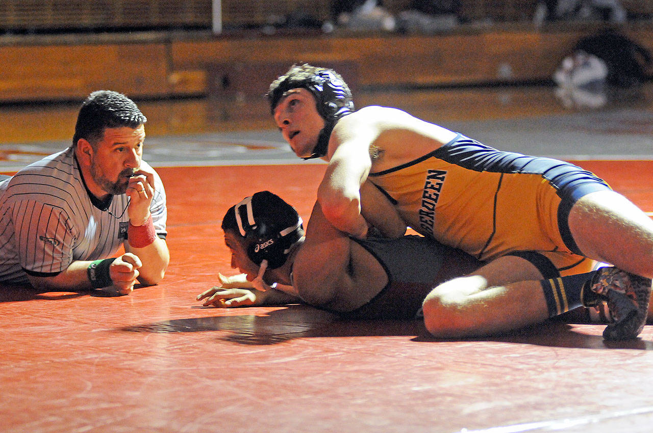 Aberdeen’s Seth Brown, top, takes a quick look at the clock in his 170-pound match against Hoquiam’s Joe Rodgers on Friday at Hoquiam High School. Brown would win the match via pinfall. (Ryan Sparks | Grays Harbor News Group)
