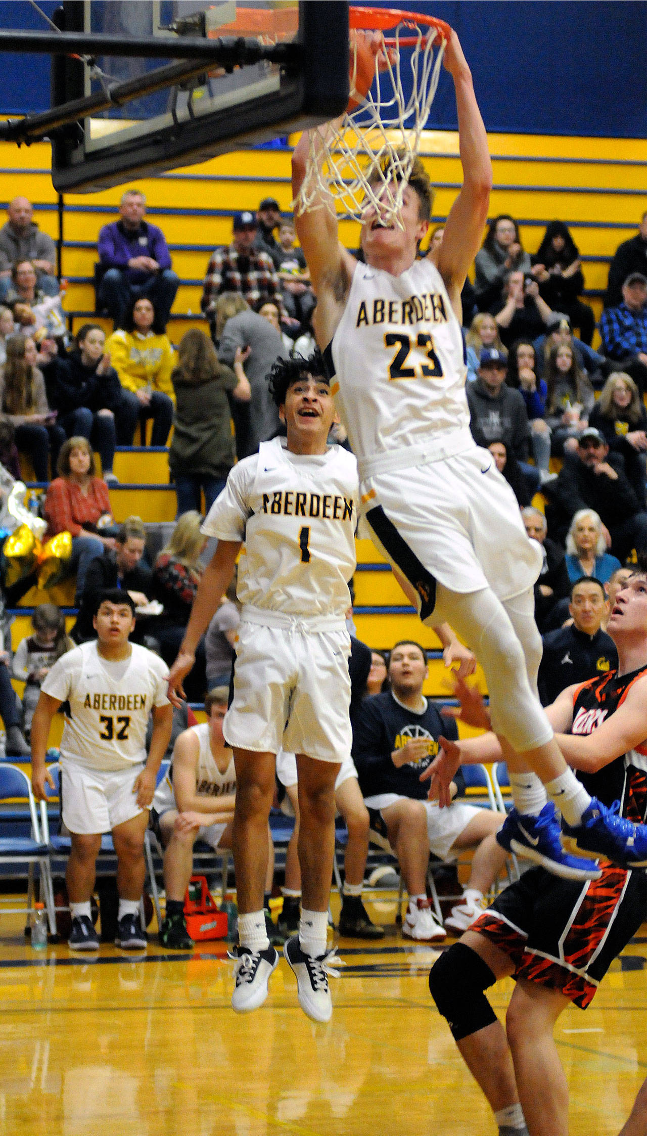 Aberdeen’s Wyatt Johnson throws down a slam dunk while teammate Angel Baltazar (1) looks on during the third quarter of Aberdeen’s 61-49 victory on Tuesday at Sam Benn Gym in Aberdeen. (Ryan Sparks | Grays Harbor News Group)