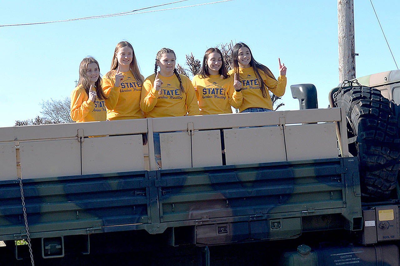 Members of the Aberdeen High School Girls Wrestling team pose on the back of an Army National Guard truck during a state tournament sendoff ceremony on Thursday. They will compete at Mat Classic XXXII in the Tacoma Dome on Saturday. (Thorin Sprandel | Grays Harbor News Group)