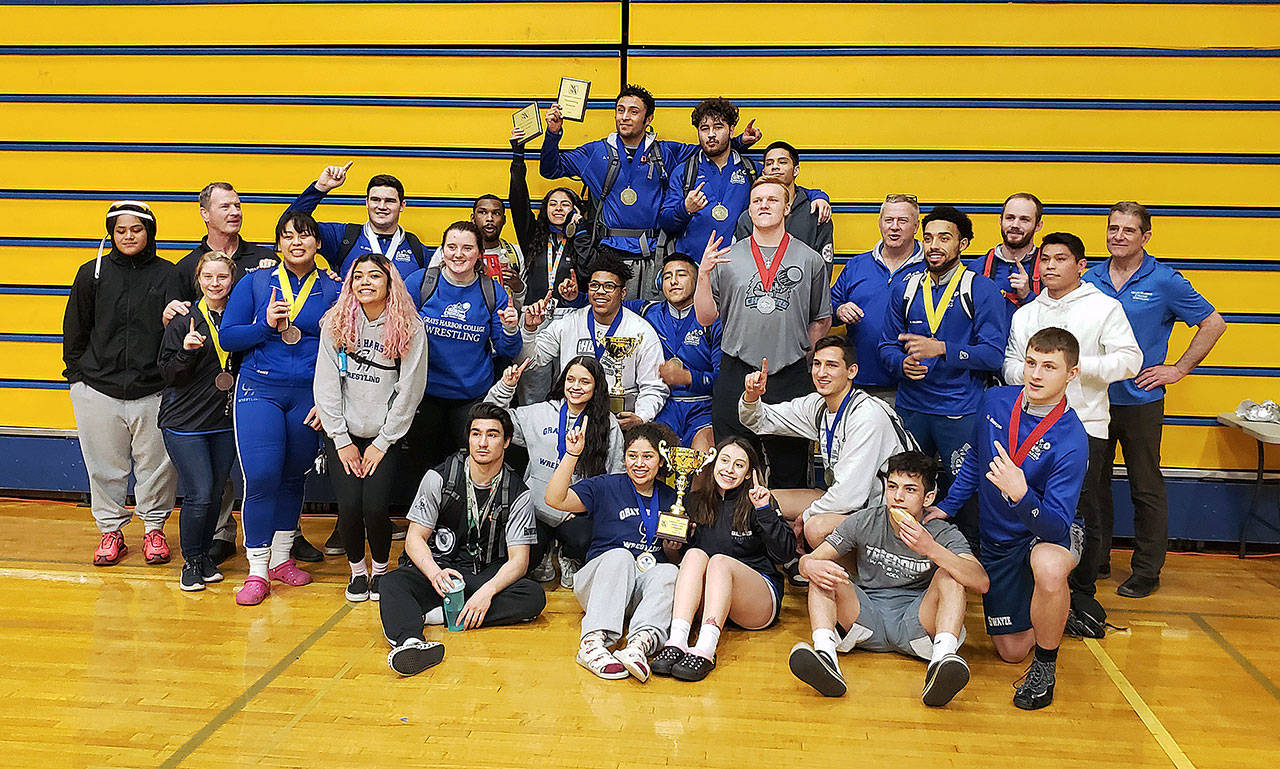 The men’s and women’s Grays Harbor wrestling teams pose for a group photo after winning the NCWA Northwest Championships on Sunday at Aberdeen High School. (Ryan Sparks | Grays Harbor News Group)