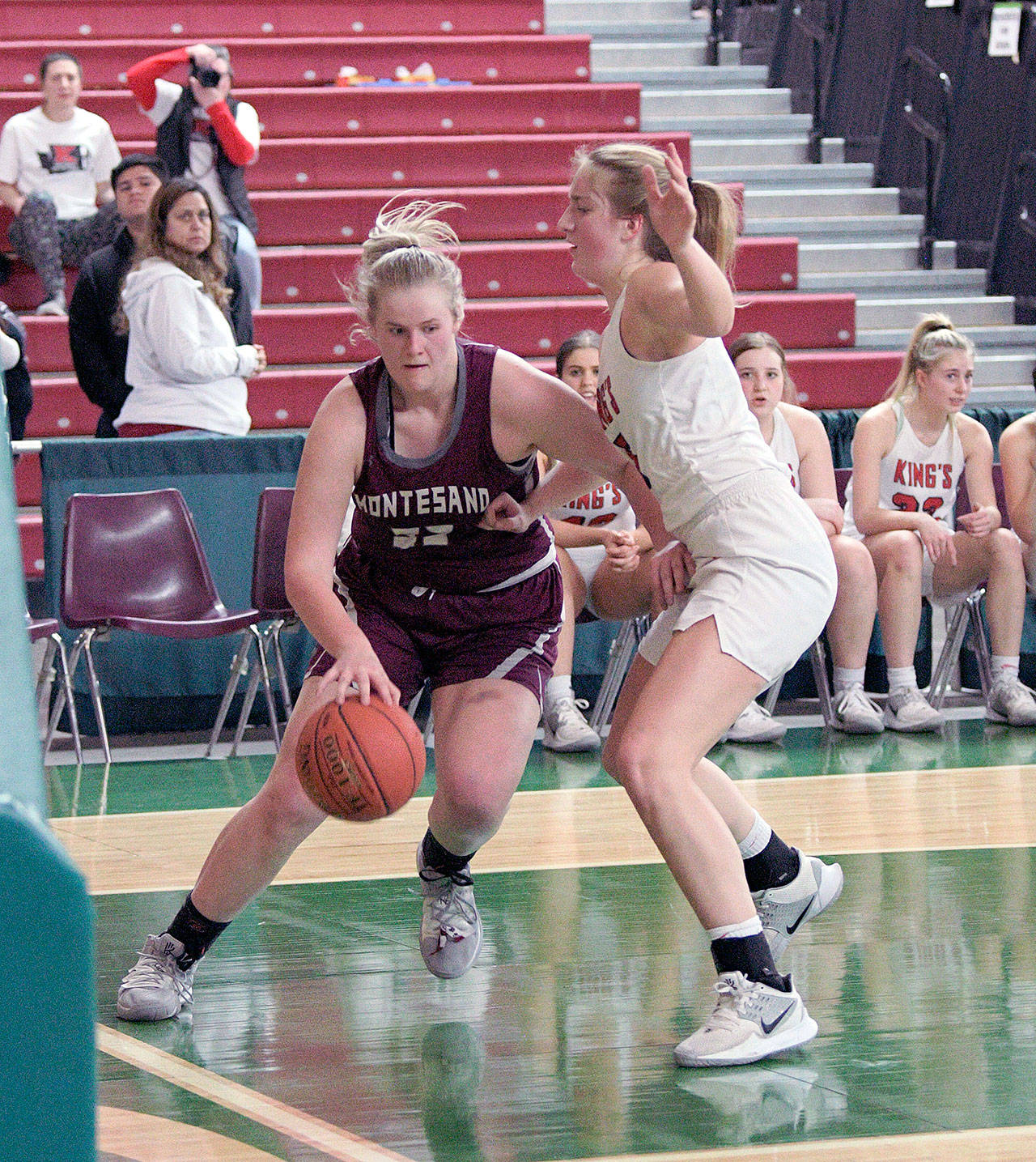 Montesano senior Zoe Hutchings, left, dribbles against Kings’ Mia Flor during the Bulldogs’ 65-43 loss on Wednesday in the first round of the 1A State Tournament at the SunDome in Yakima. (Photo by Robert Beldin)