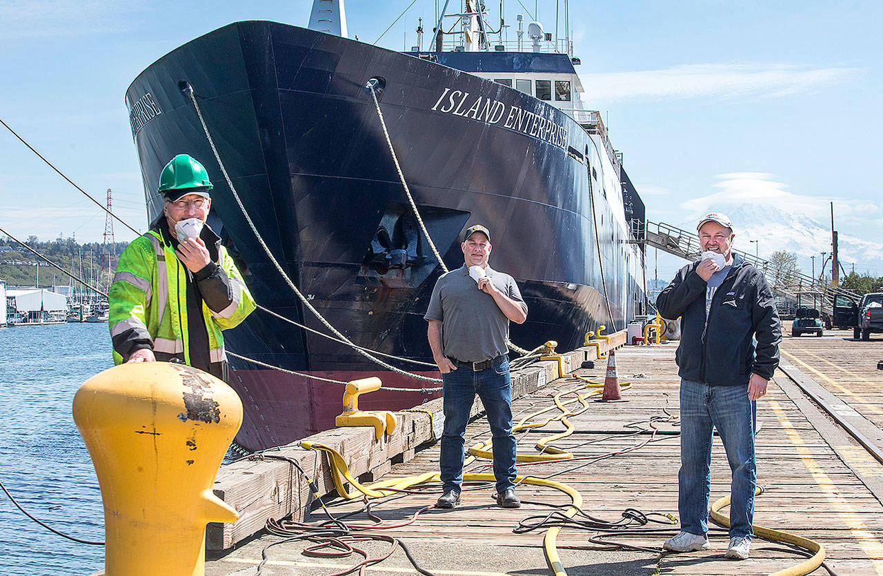 Steve Ringman/Seattle Times                                 From left, Trident Seafoods’ Tod Hall, manager of vessel operations; Roger Lebel, Island Enterprise purser, and Mike Luchino, director of operations for Catchers Processors group at the Tacoma pier where the ships are being prepared for the trip to Alaska.
