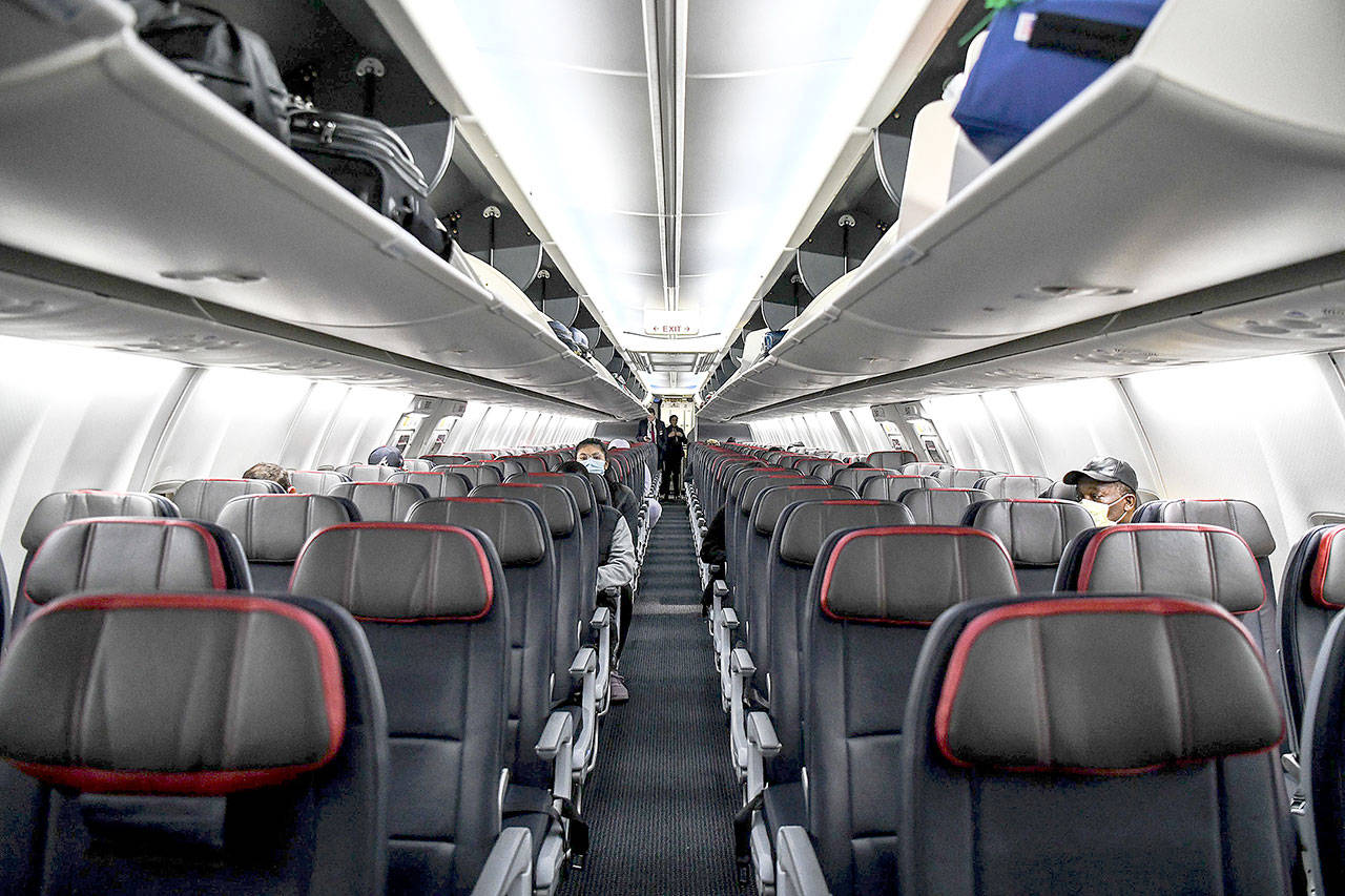 Passengers sit at a distance inside a flight from Miami to Atlanta last week. (Chandan Khanna/Getty Images)