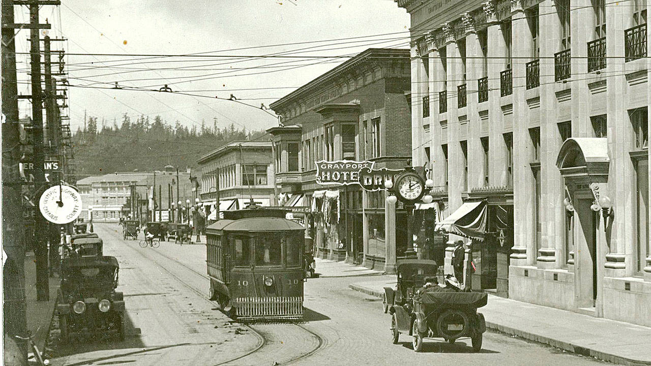 I Street (now Simpson) looking north from 8th Street. Heikel’s Drug is visible at 721 I Street in the First National Bank building at right, its sign nestled between the street clock and the Grayport Hotel sign. All street car patrons were required to wear masks at the height of the pandemic.