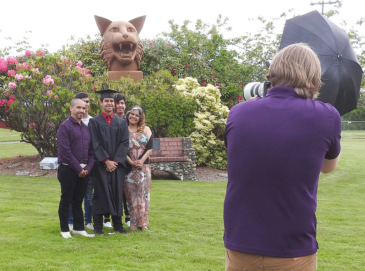 Kat Bryant | Grays Harbor News Group Graduating senior Jose Figueroa-Tinoco poses with his family Saturday for an official photo in front of the Ocosta Jr./Sr. High School Wildcat. Afterward, they walked into the gym to record Jose walking across the stage to receive his diploma cover.