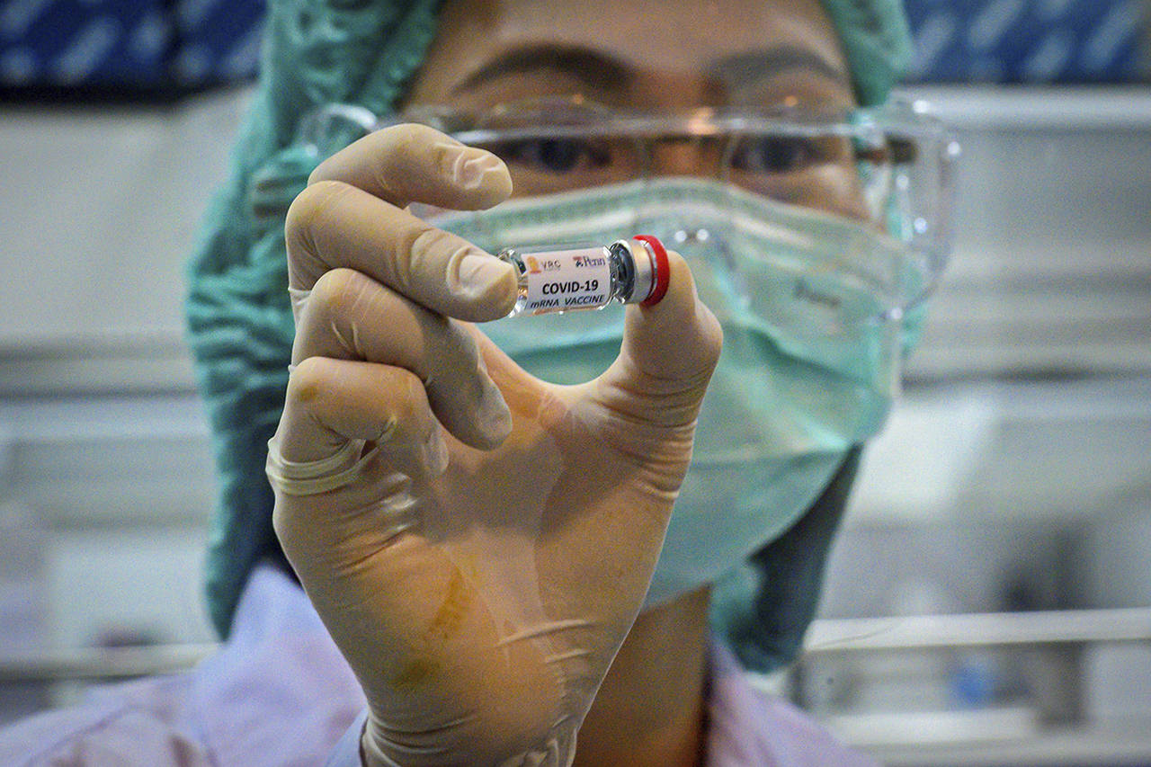 A laboratory technician holds a dose of a COVID-19 novel coronavirus vaccine candidate that’s ready for trial on monkeys at the National Primate Research Center of Thailand. (Mladen Antonov | AFP)